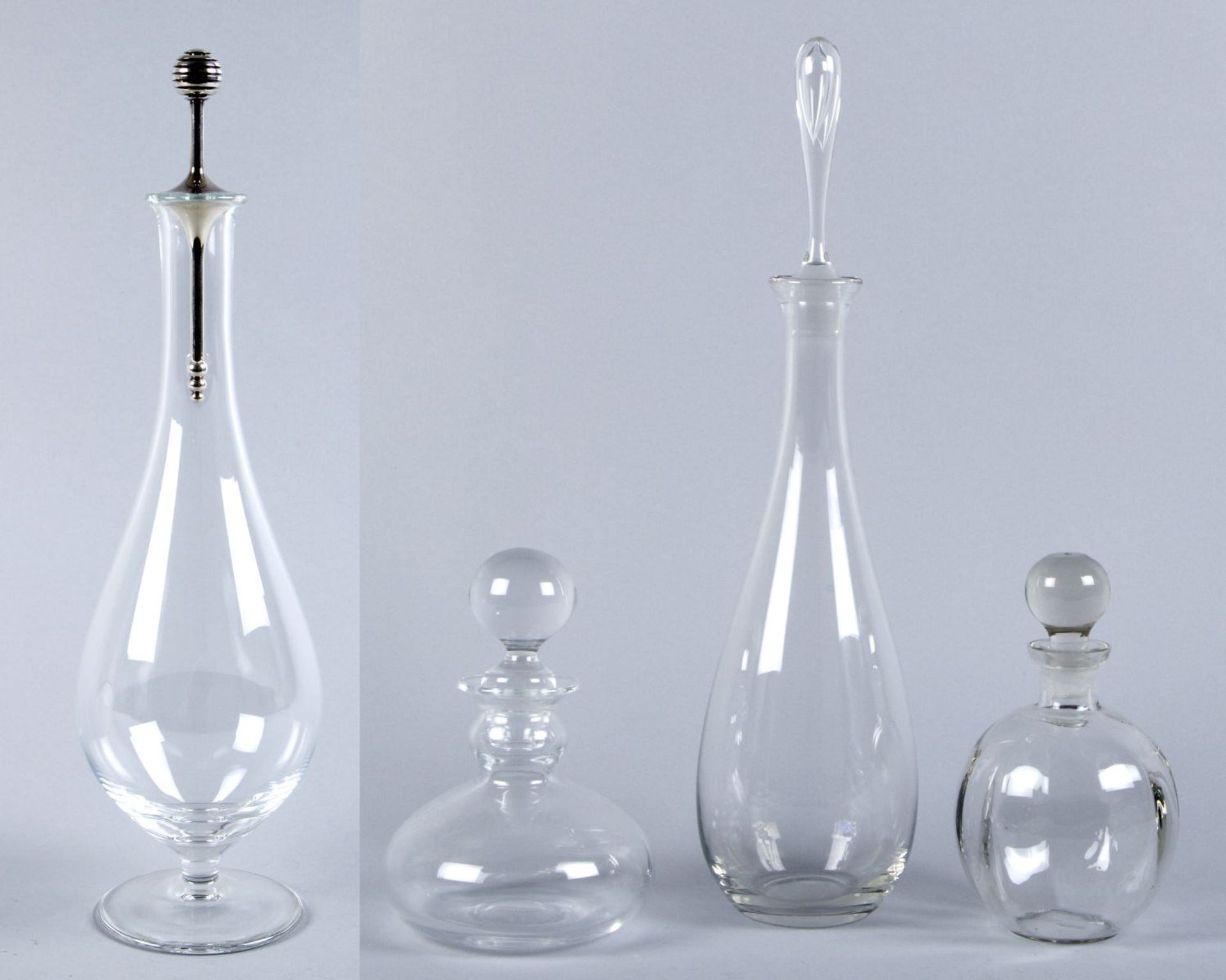 Vier Karaffen mit StöpselnFarbloses Glas. Versch. Formen. H. bis 45 cm.