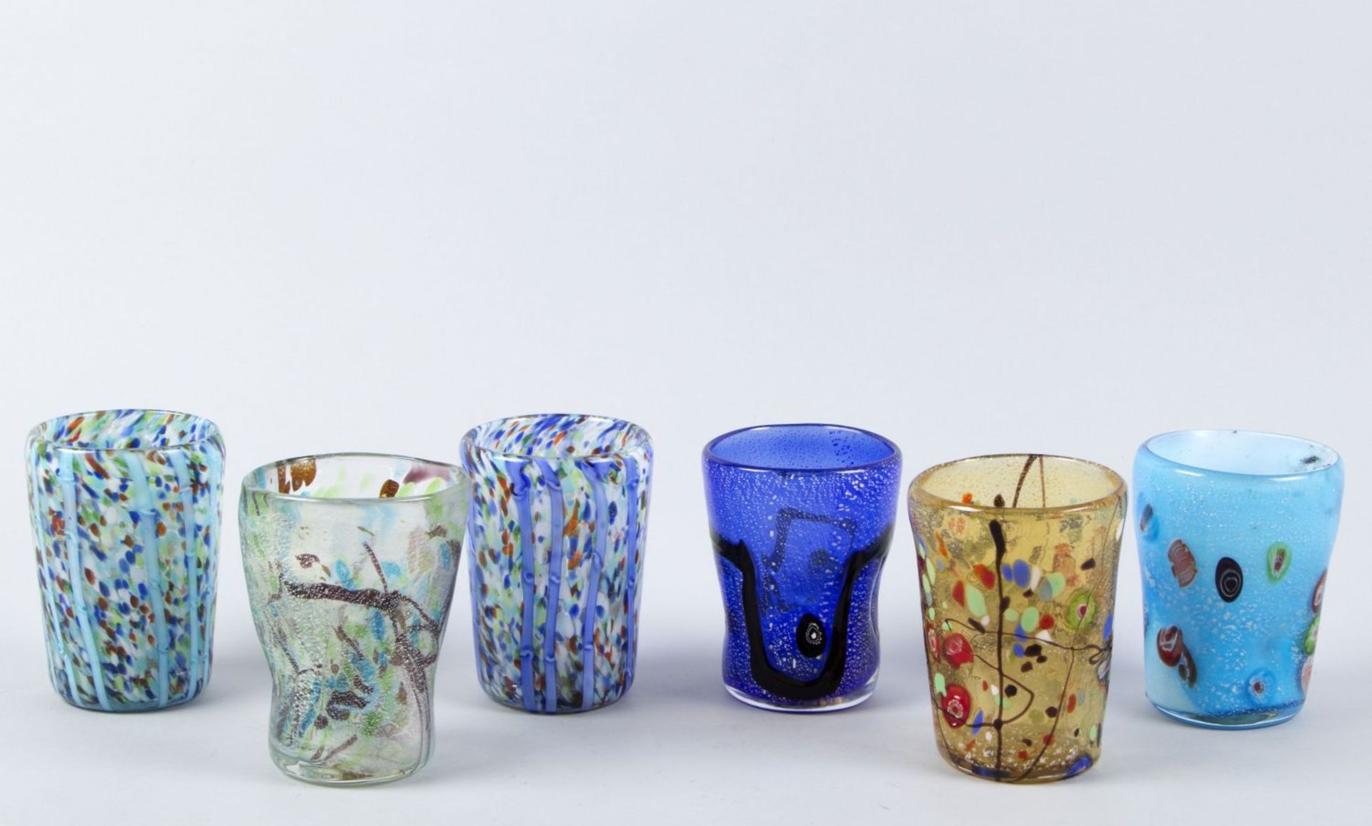 Sechs BecherFarbloses Glas. Versch.farbige Dekore, u.a. blau bzw. weiß unterfangen. Polychrome