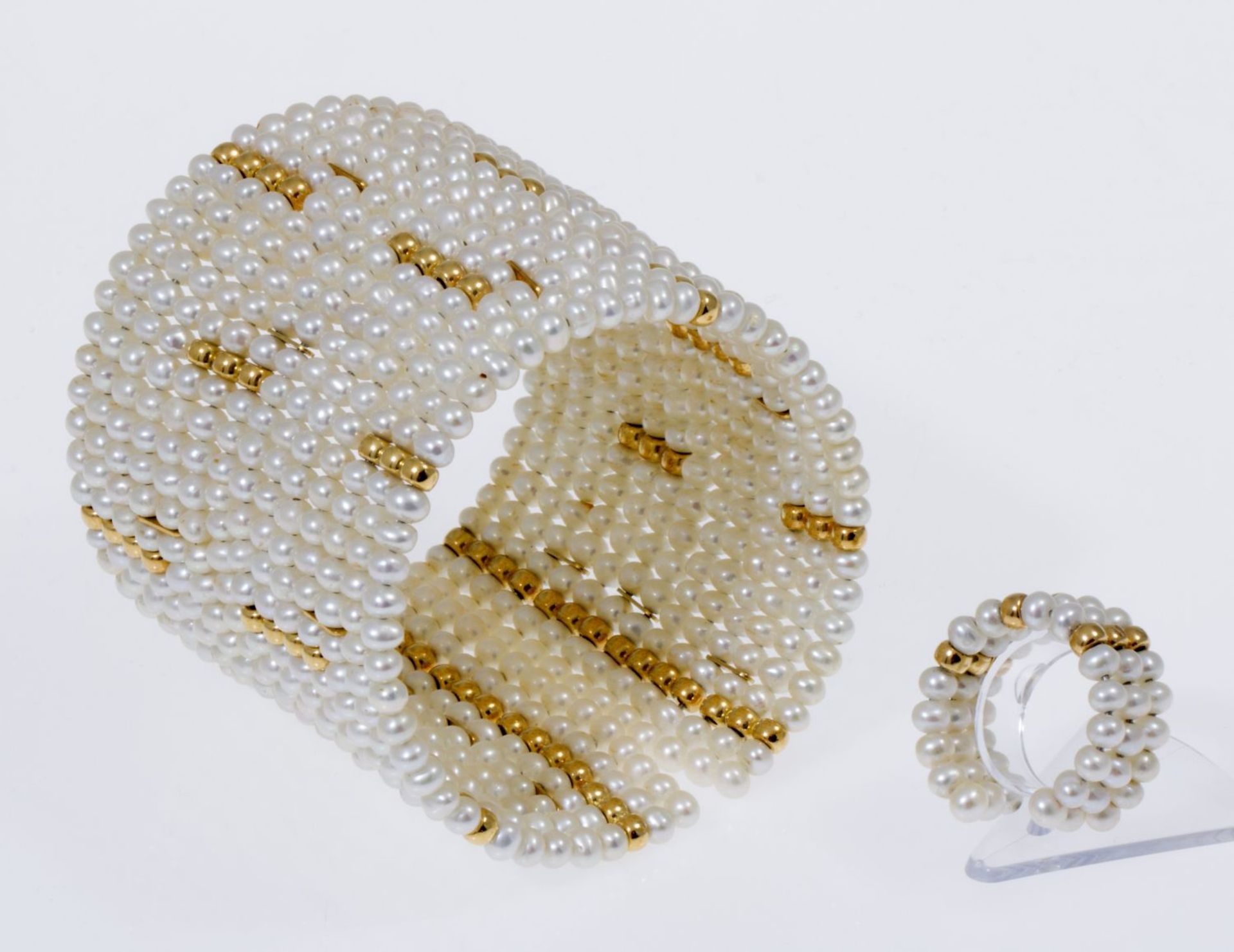 Breite Perlenarmspange in Manschettenform und passender SpangenringZahlreiche kleine cremefarbene