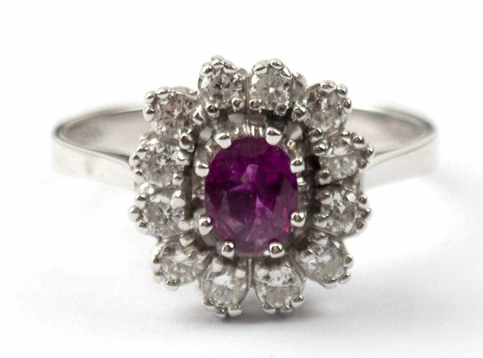 Ring, 585er WG, ausgefasst mit 12 Brillanten von zus. ca. 0,36 ct. und 1 oval facettiertemRubin,