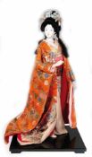 Japanische Geisha-Figur, Kunststoff, auf viereckiger schwarz lackierter Holzplatte,