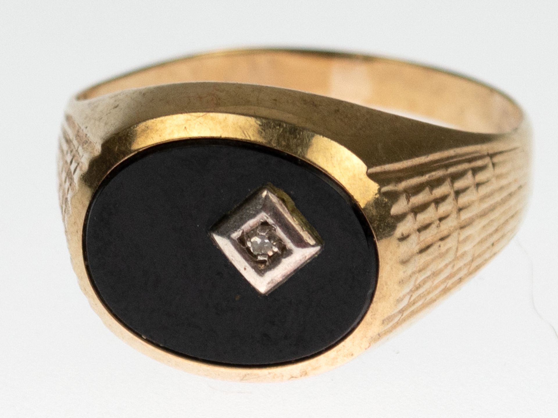 Herren-Siegelring, 333er GG, besetzt mit ovalem Onyx und kleinem Diamant in der Platte, RG62