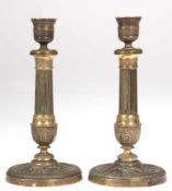 Paar Empire-Kerzenleuchter, Bronze, floraler Reliefdekor, Schaft kanneliert, Stand und Tülle etwas