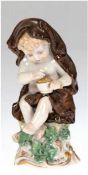 Porzellanfigur "Putto", unterseitig gemarkt, polychrome Bemalung, leicht best., H. 13 cm