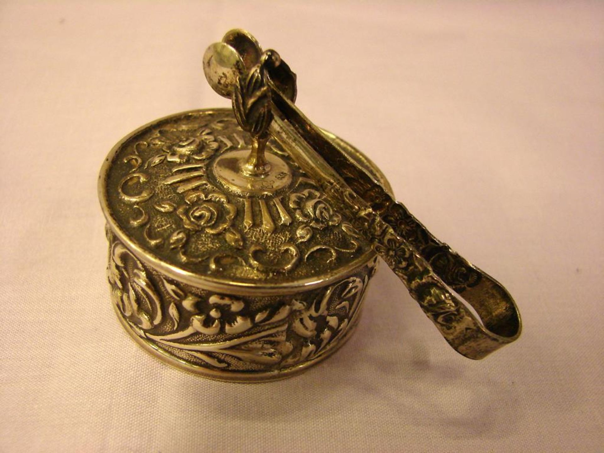 Kleine Pillendose, rund, reich verziert, 835er Silber, mit kleiner Zange, ca. 31 gr., H. ca. 4 cm,