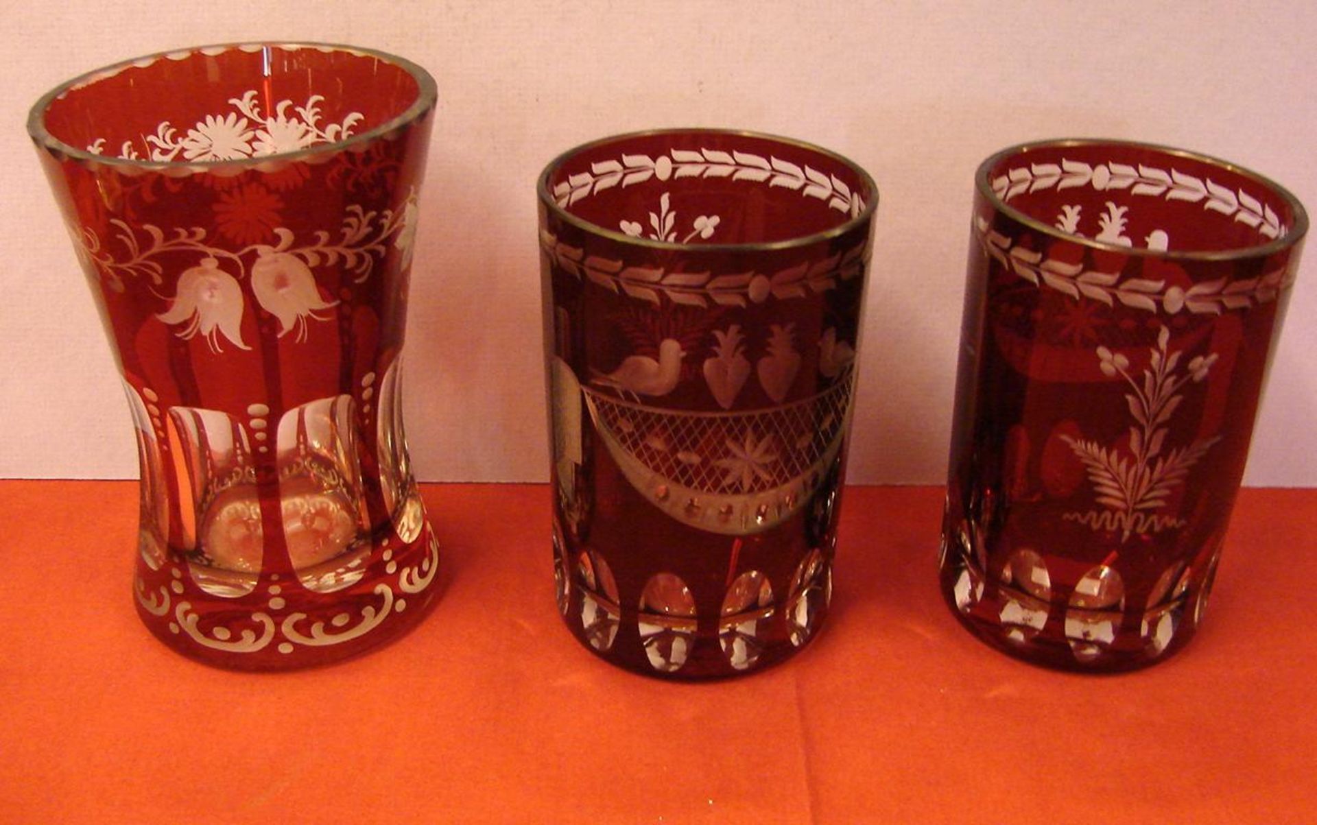 3 Böhmische Gläser, 2 Trinkgläser H 11,5 cm, 1 pokalförmiges Glas, rubinfarben, Zierschliff, H. ...