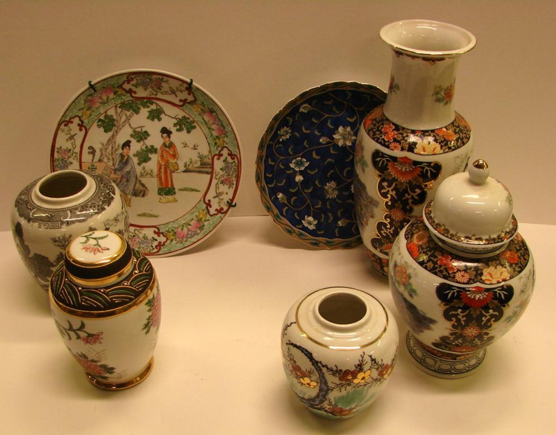 Konvulut asiatisches Porzellan, 7 Teile, 2 Teller, 3 Vasen, 2 Deckeldosen, mit farbigen Motiven