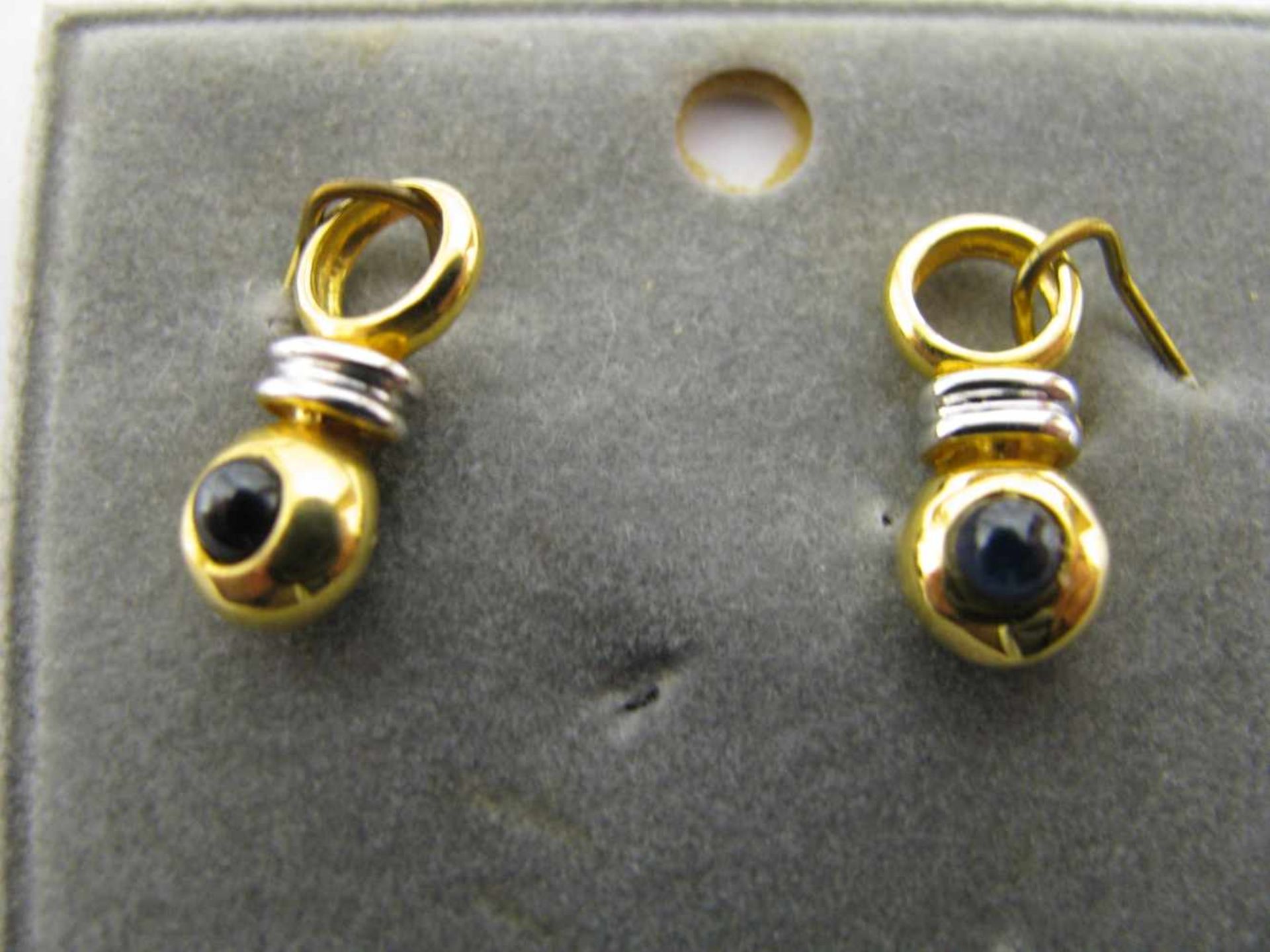 2 Anhänger, 2 Saphircabochons, 333er Gelb- und Weißgold, gepunzt, 1,8 g, l 1,6 cm.<b