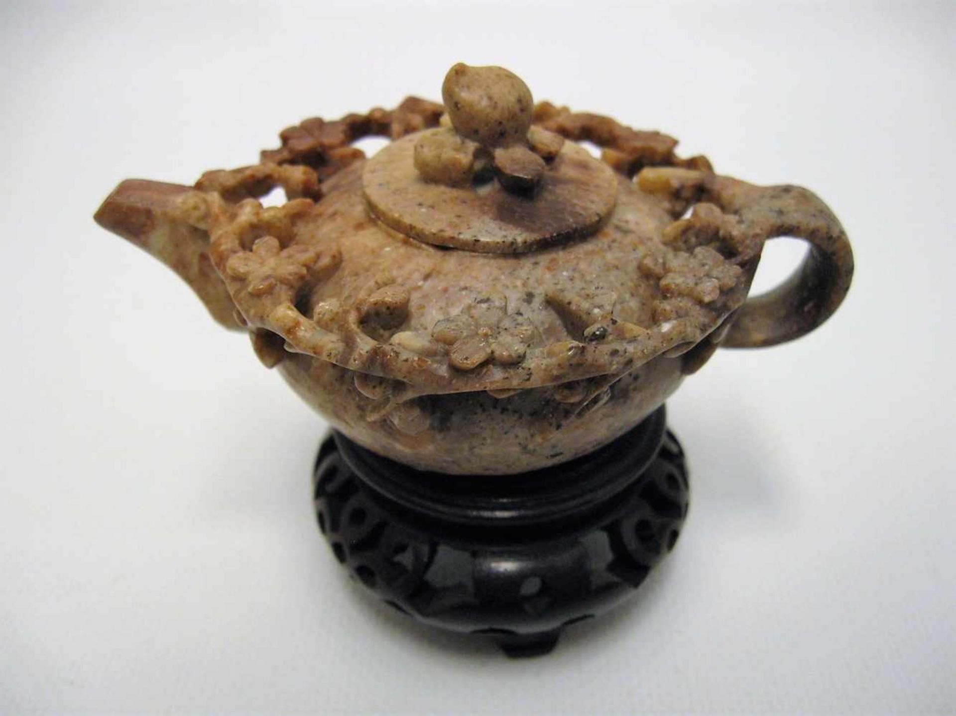 Teekanne, China, Speckstein beschnitzt, beschnitzter Holzsockel, h 8 cm, d 10 cm.