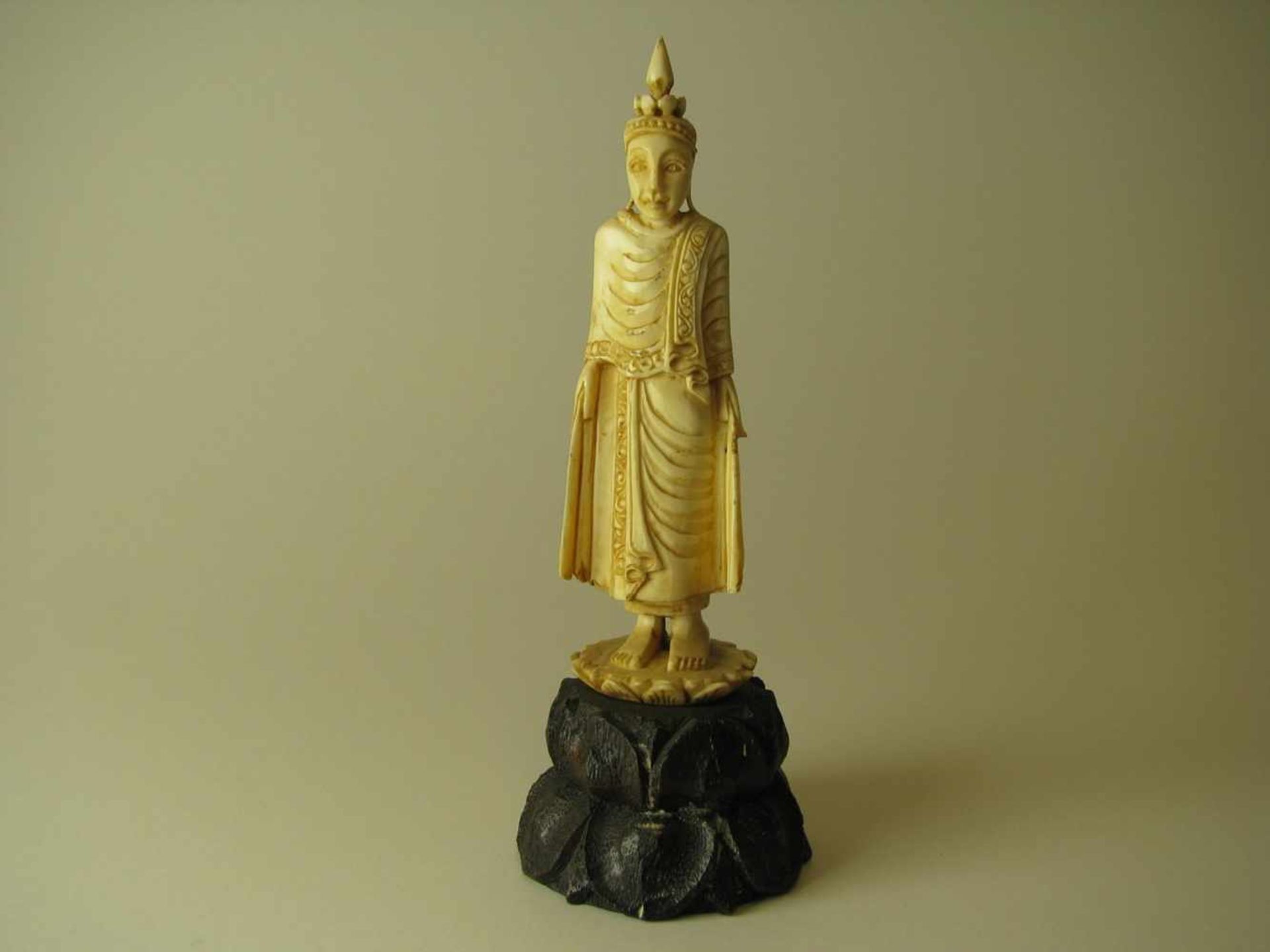 Buddhafigur, Südostasien, um 1900, Elfenbein beschnitzt, Holzsockel, h 10,5 cm, d 3,5 cm.<
