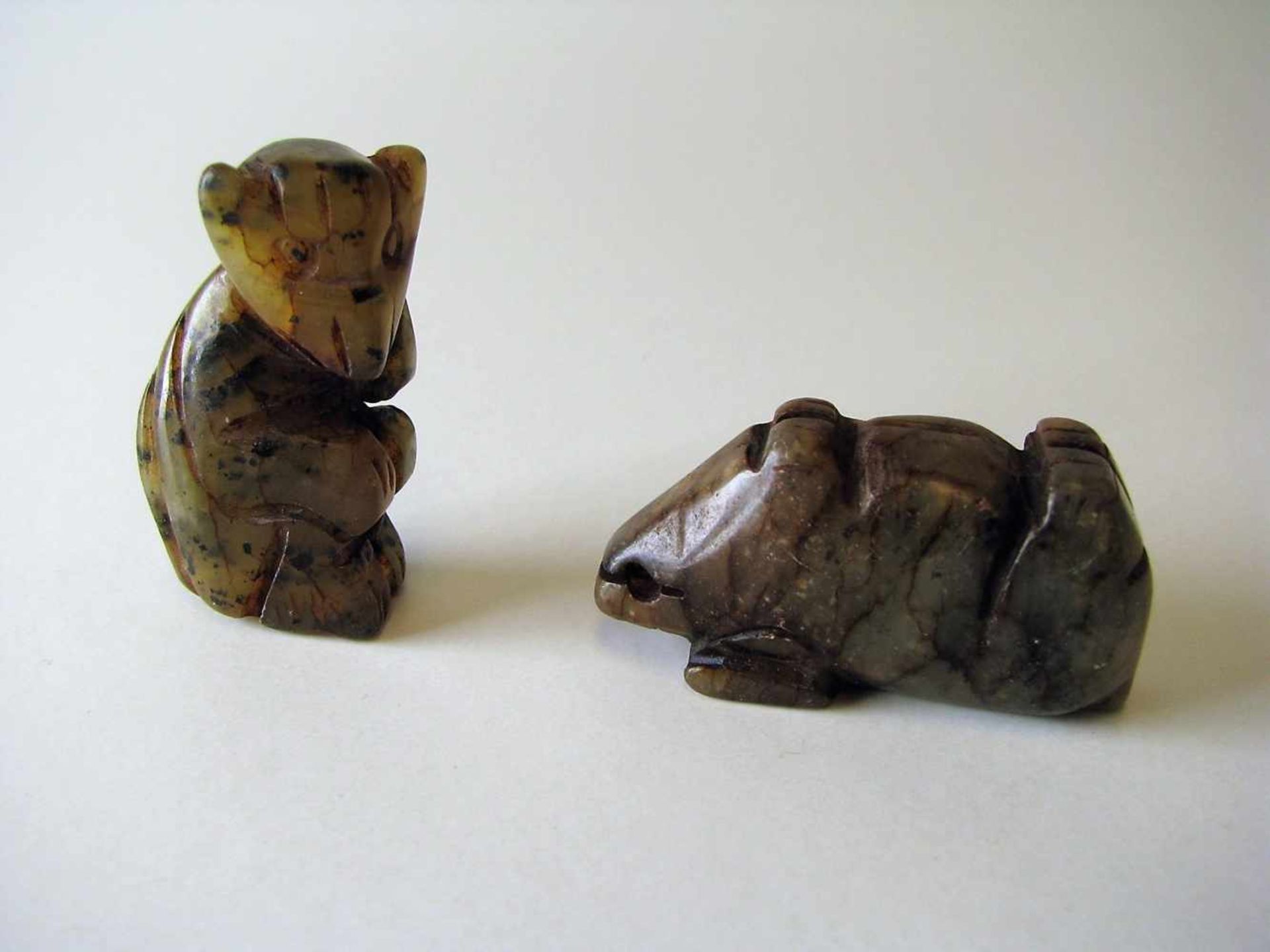 2 Anhänger, "Schwein" und "Affe", grün-bräunliche Jade beschnitzt, h 4/2 cm.<br