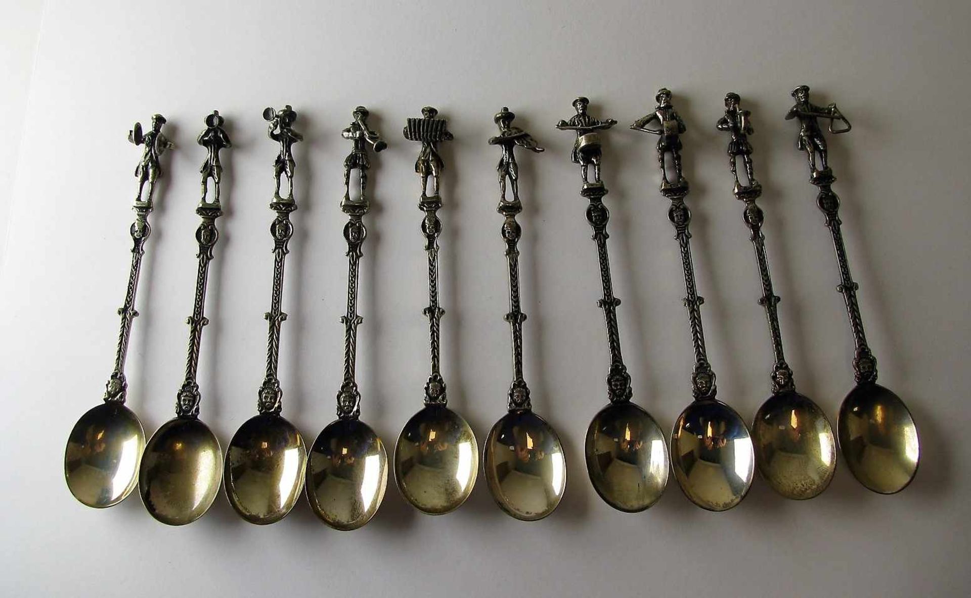 10 Teelöffel mit Musizierenden, 835er Silber, gepunzt, 142 g, l 12 cm.<