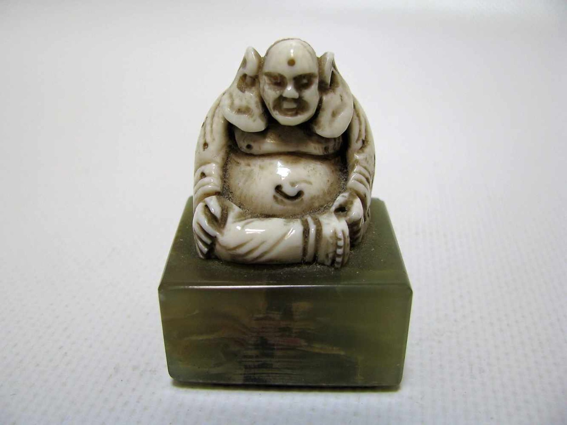Sitzender Buddha, China, um 1900, Elfenbein fein beschnitzt, Onyxsockel, 4,5 x 3,2 x 2,5 cm.