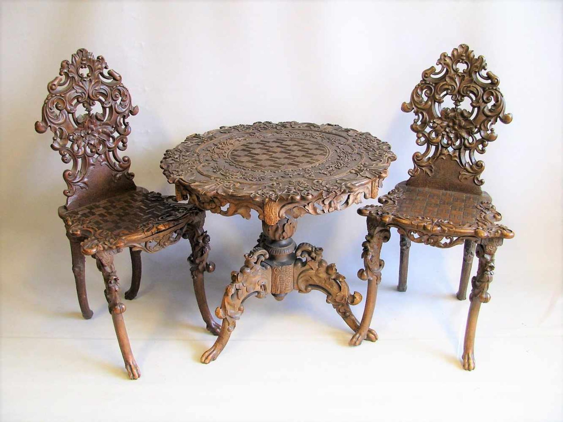 Tisch und 2 Stühle, Süddeutsch, 19. Jahrhundert, Nussbaum reich beschnitzt, Tisch h 60 cm, d 68