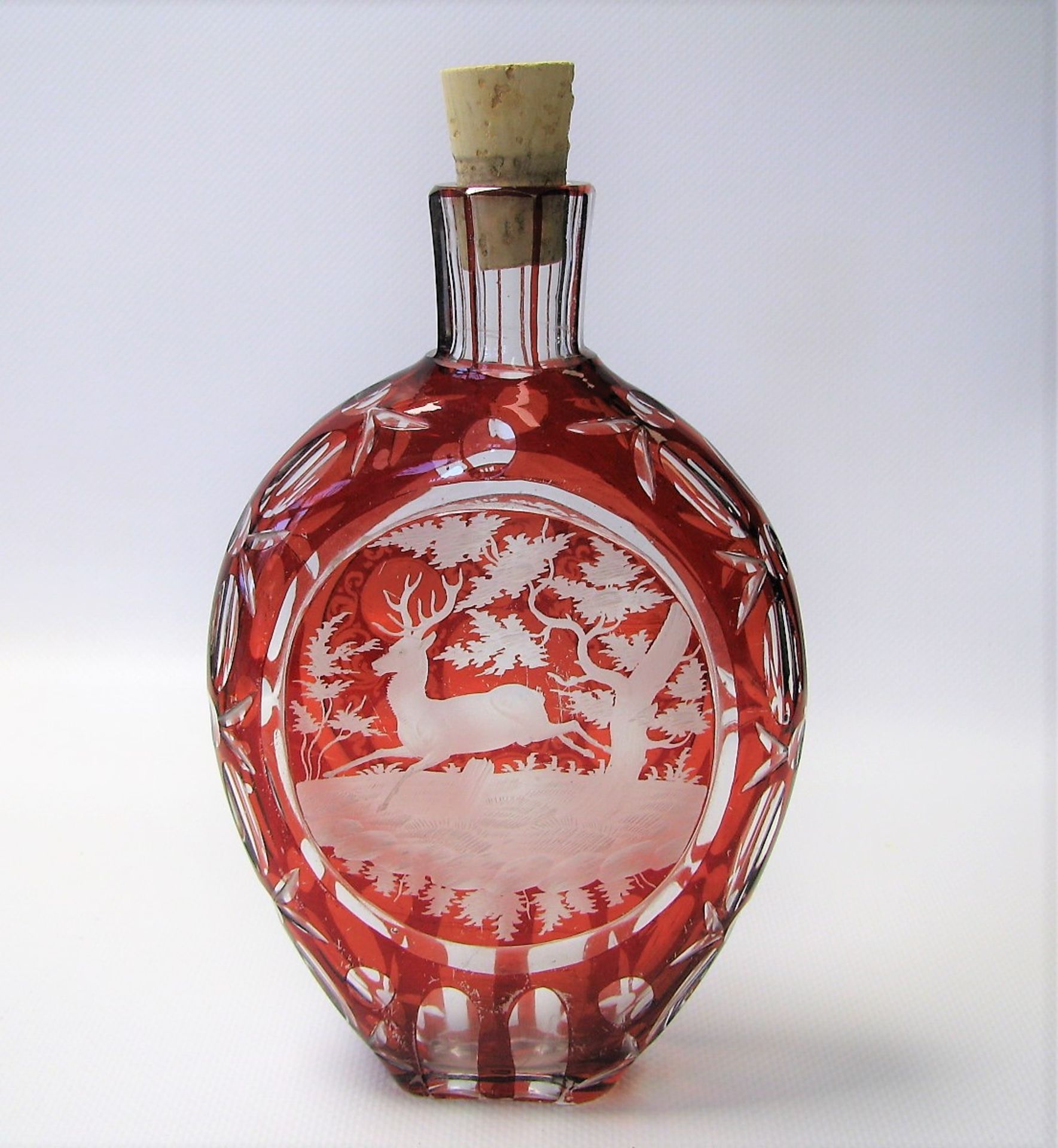 Schnapsflasche, Böhmen, Glas rubiniert, jagdlicher Schliff, 17 x 11 x 4 cm.