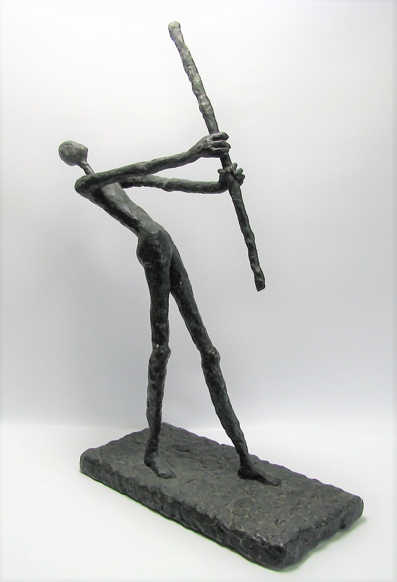 Unbekannt, Männliche Figur mit Stab, Bronze patiniert, 50,5 x 15,5 x 31 cm.
