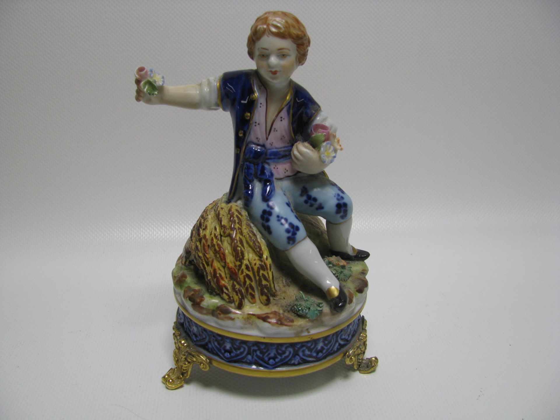 Porzellanfigur, Knabe mit Getreide und Blüten, Frankreich, Porzellan mit polychromer Bemalung, gem.,