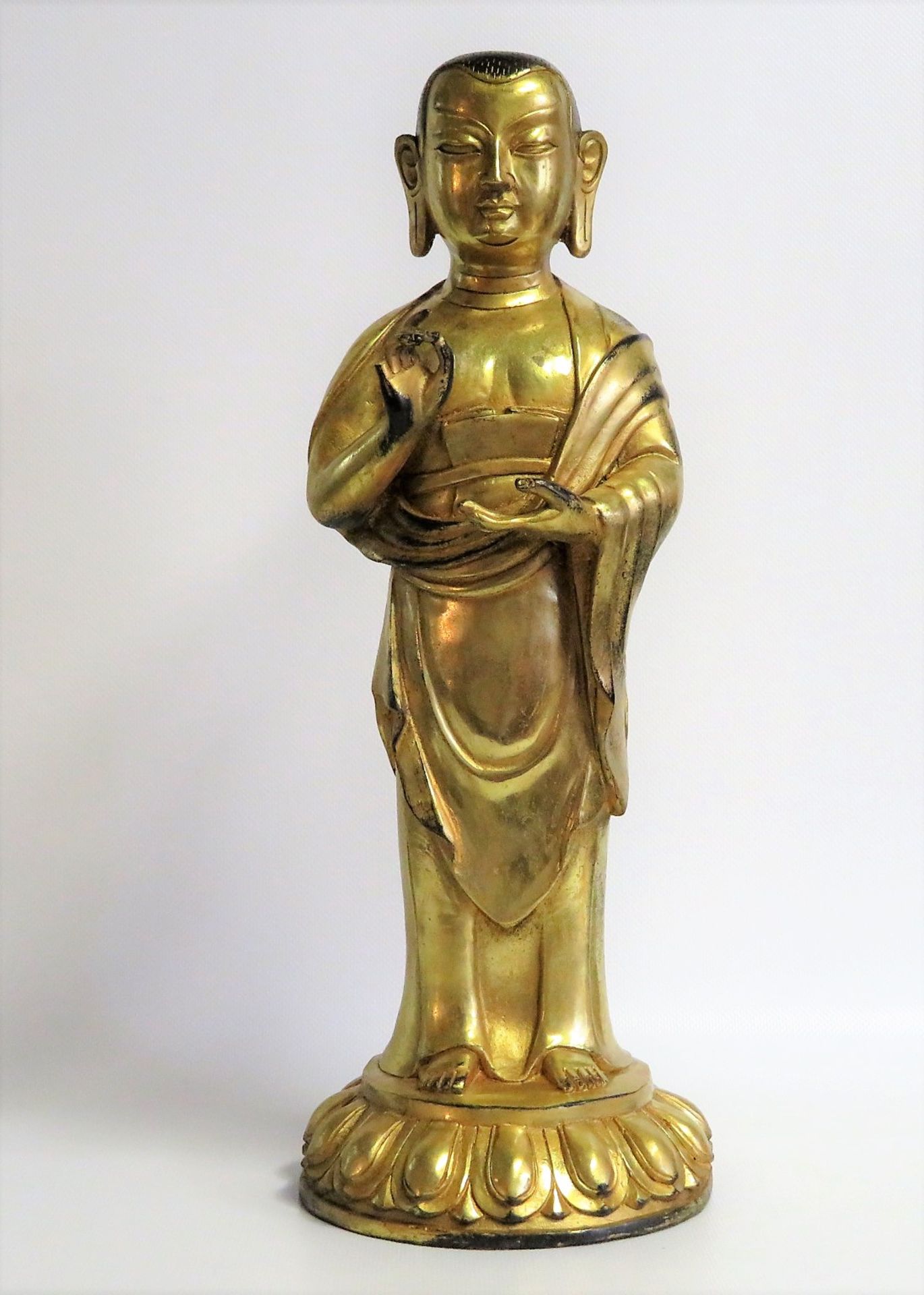Stehende Buddhafigur auf Lotusthron, wohl Tibet/Nepal, Bronze mit Blattvergoldung, geschlossene