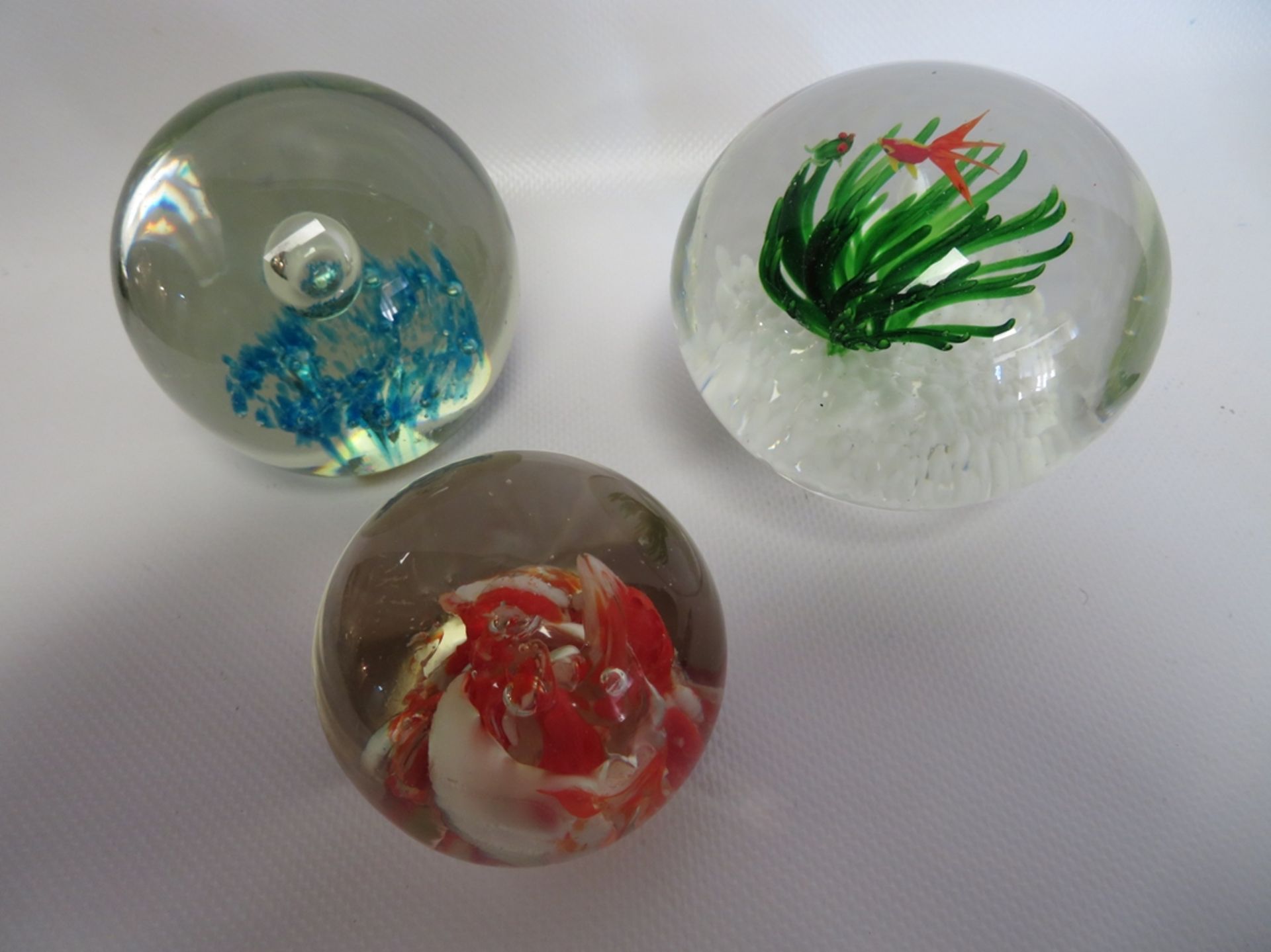 3 diverse Paperweights, Italien, farbloses Glas mit farbigen Einschmelzungen, h 5/7/7,5 cm.