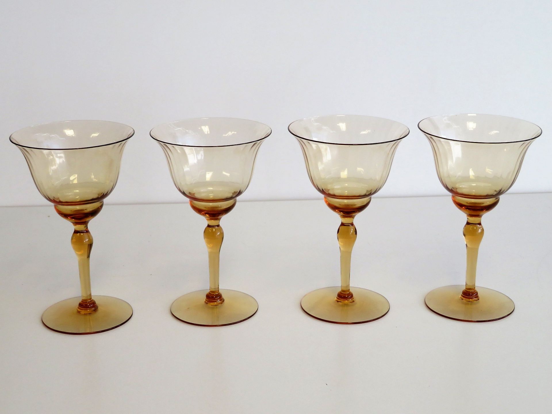 4 Weingläser, Jugendstil, um 1900, orange-bernsteinfarben eingefärbtes Glas, h 13,5 cm, d 8,5 cm.