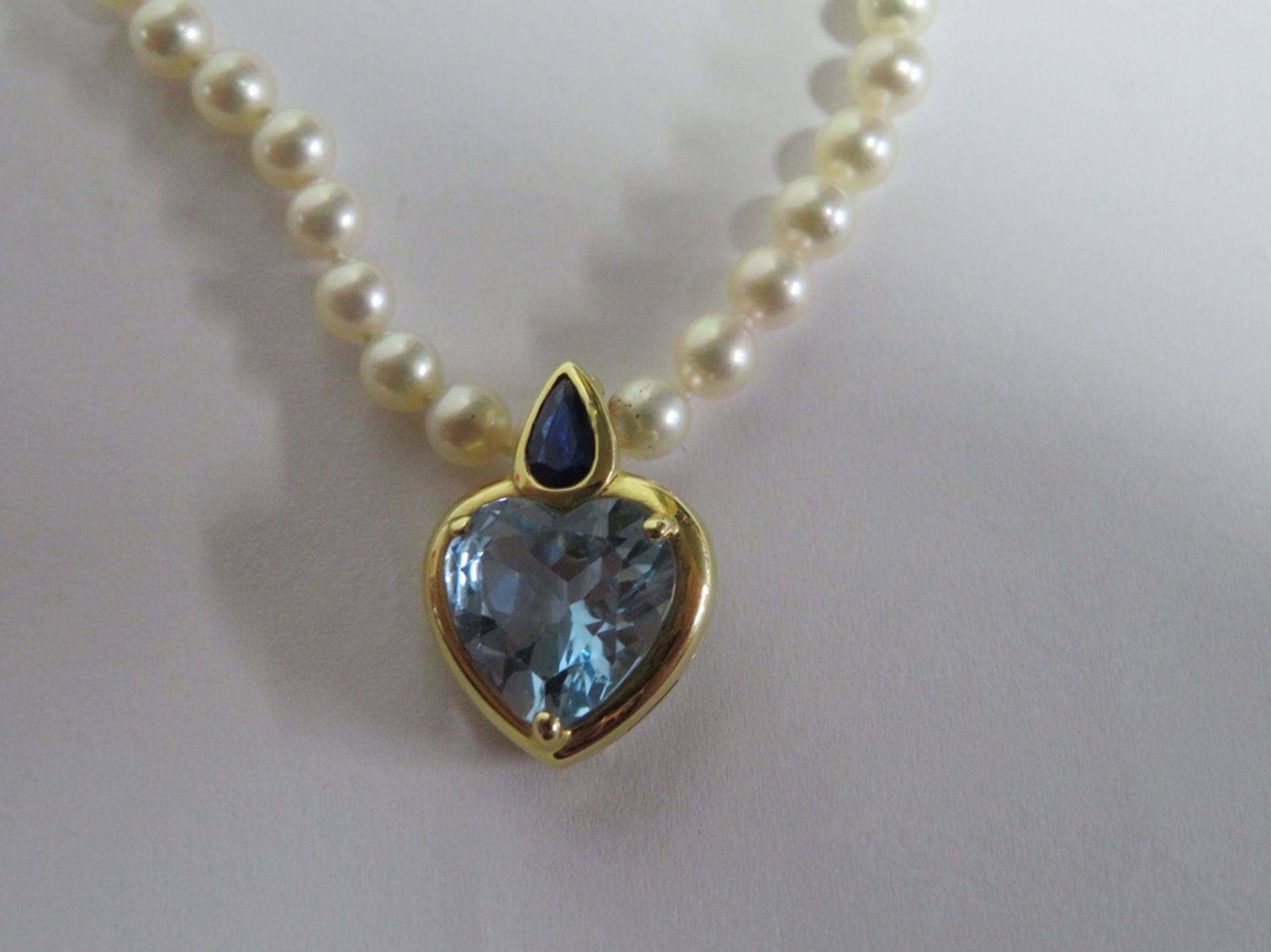 Perlenkette mit Clip-Anhänger besetzt mit herzförmigem Blautopas und tropfenförmigem Saphir,