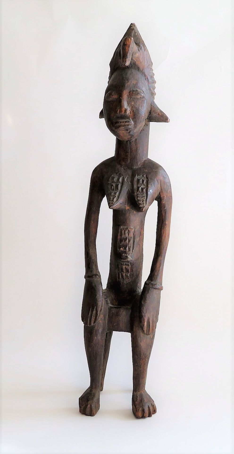 Sitzende, Afrika, wohl Yoruba, Holz geschnitzt, 43 x 9 cm.