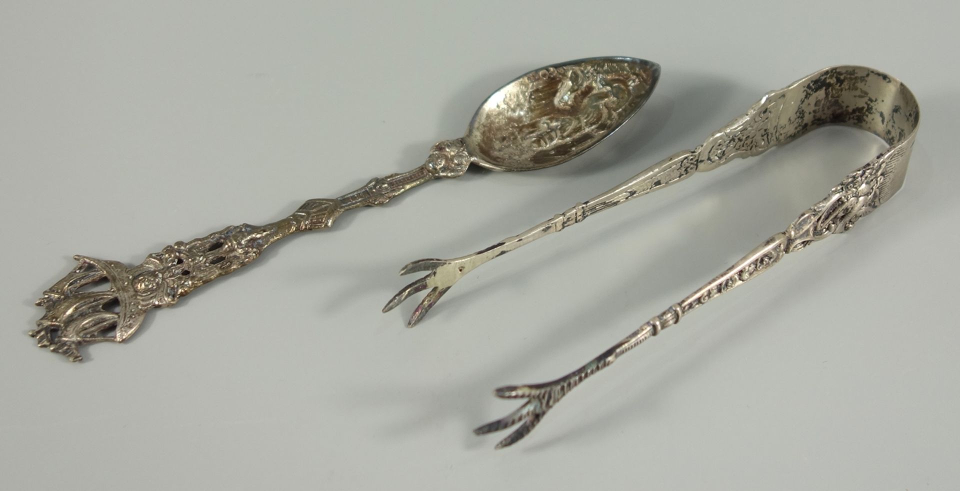 zwei Besteckteile, 800er Silber: Zuckerzange mit Krallen und turtelnden Tauben, L.12cm, Zierlöffel