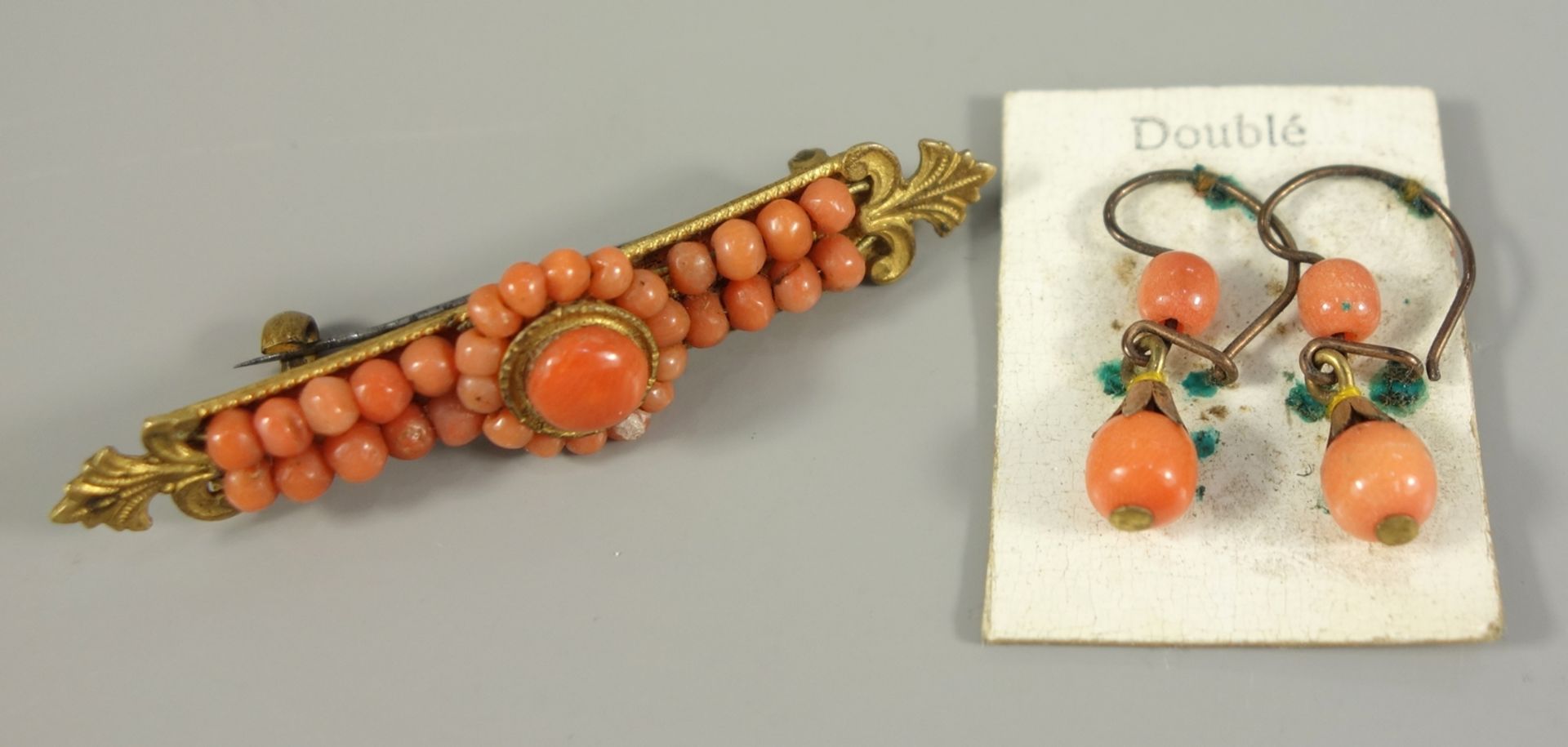 Brosche und ein Paar Ohrhänger mit Koralle, um 1920, Doublé, Brosche mit kleinen, lachsroten