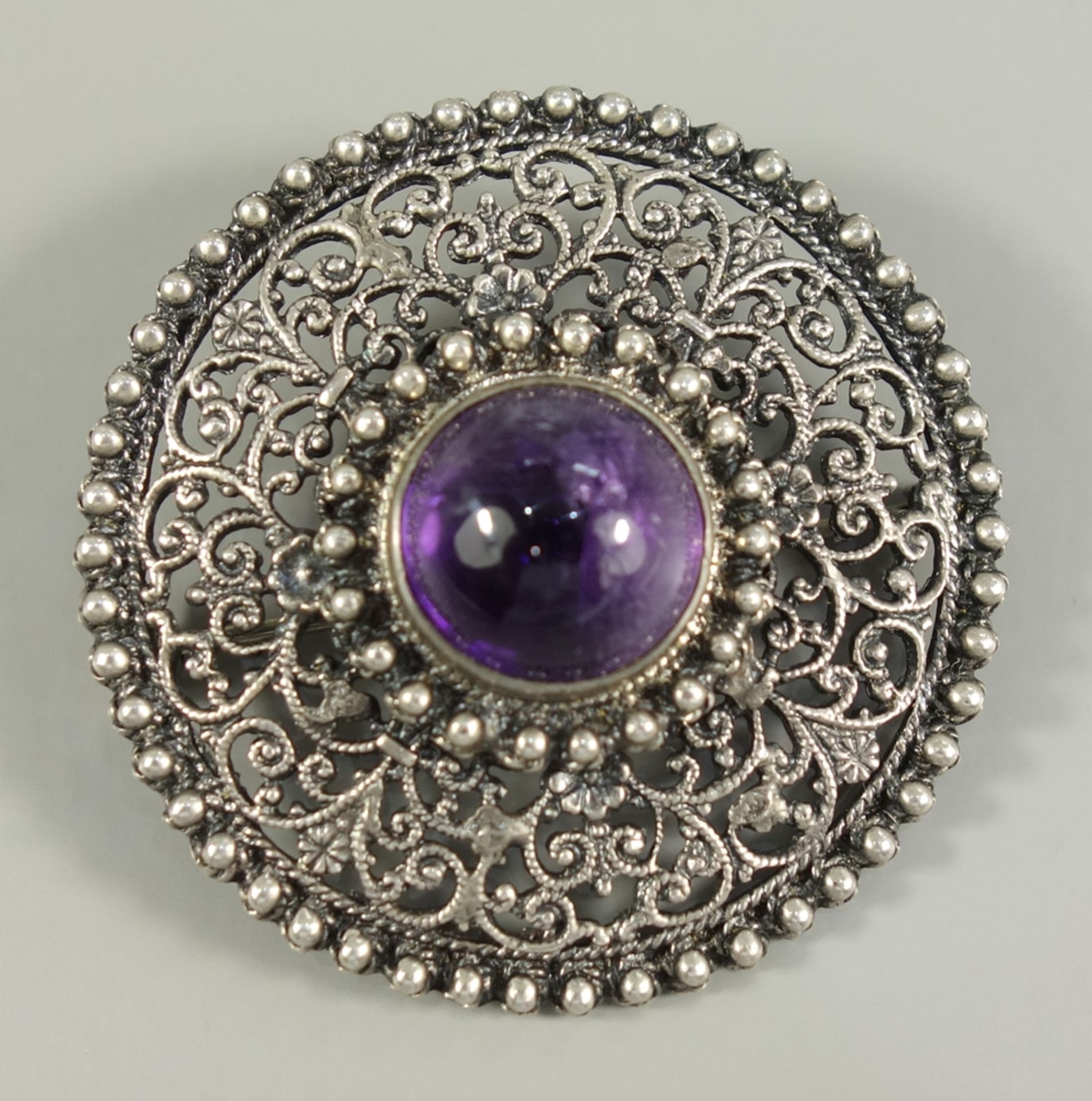 Brosche mit Amethyst-Cabochon, 835er Silber, um 1920, Gew.12,00g, rund, filigran durchbrochen,