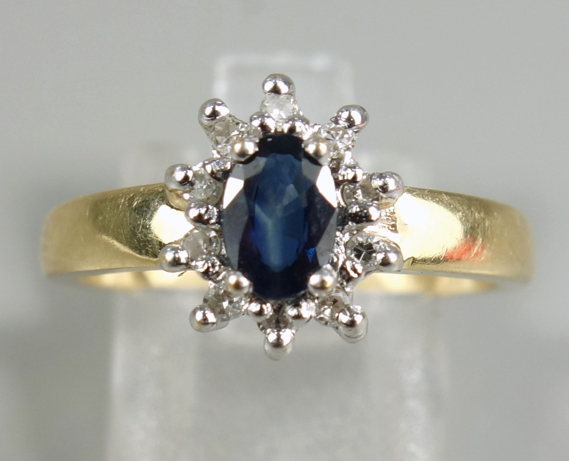 Saphir-Brillant-Ring, 585er Gold, Gew.3,74g, ovaler, facettierter Saphir, umrahmt von 10 Brillanten,