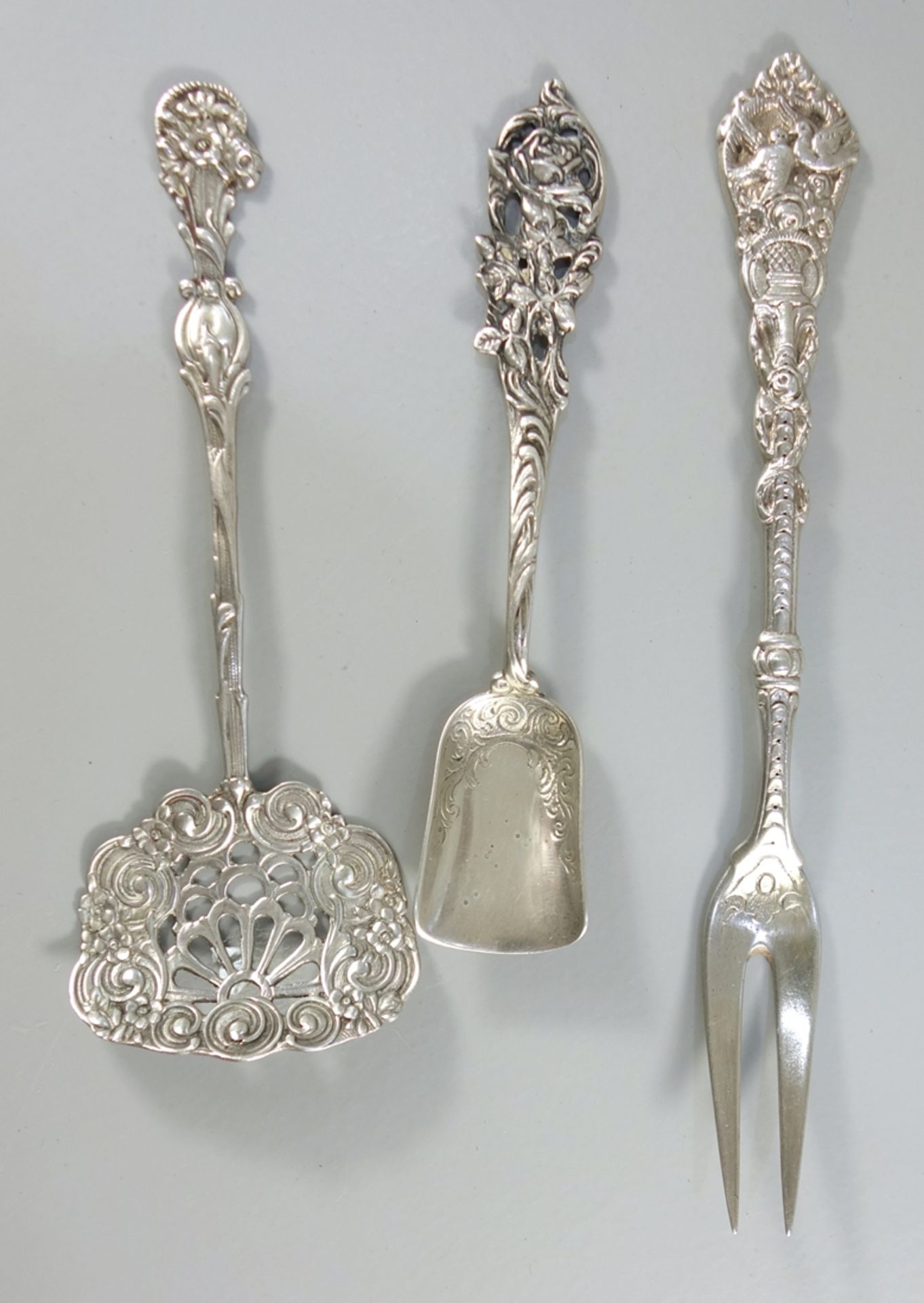 3 Anlegteile, überwiegend mit Blumendekor, 800er Silber, u.a. C. Widmann: Zuckerschaufel, kleiner