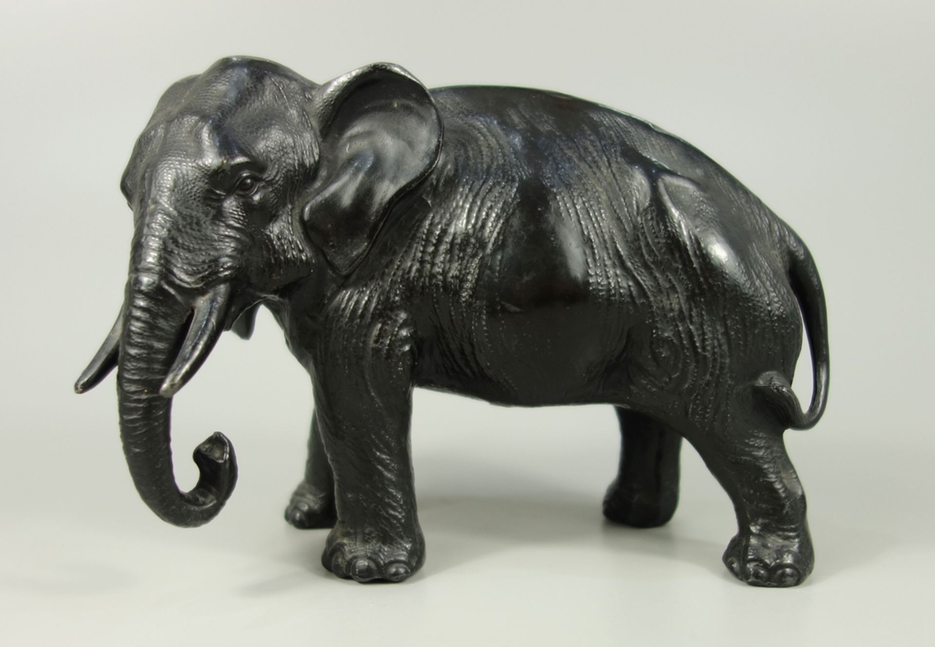 Elefant, Japan, 20.Jh., H.12cm, Spritzguss, dunkel patiniert, am Baucn reliefierter Aufdruck "Made