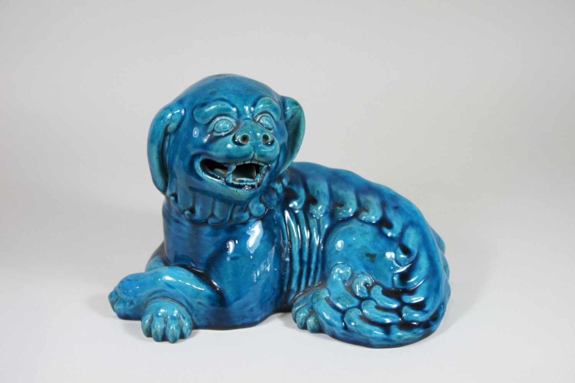 Fohund, China, 20. Jh., liegend, mit türkiser Glasur, H.: 18 cm, B.: 25 cm.