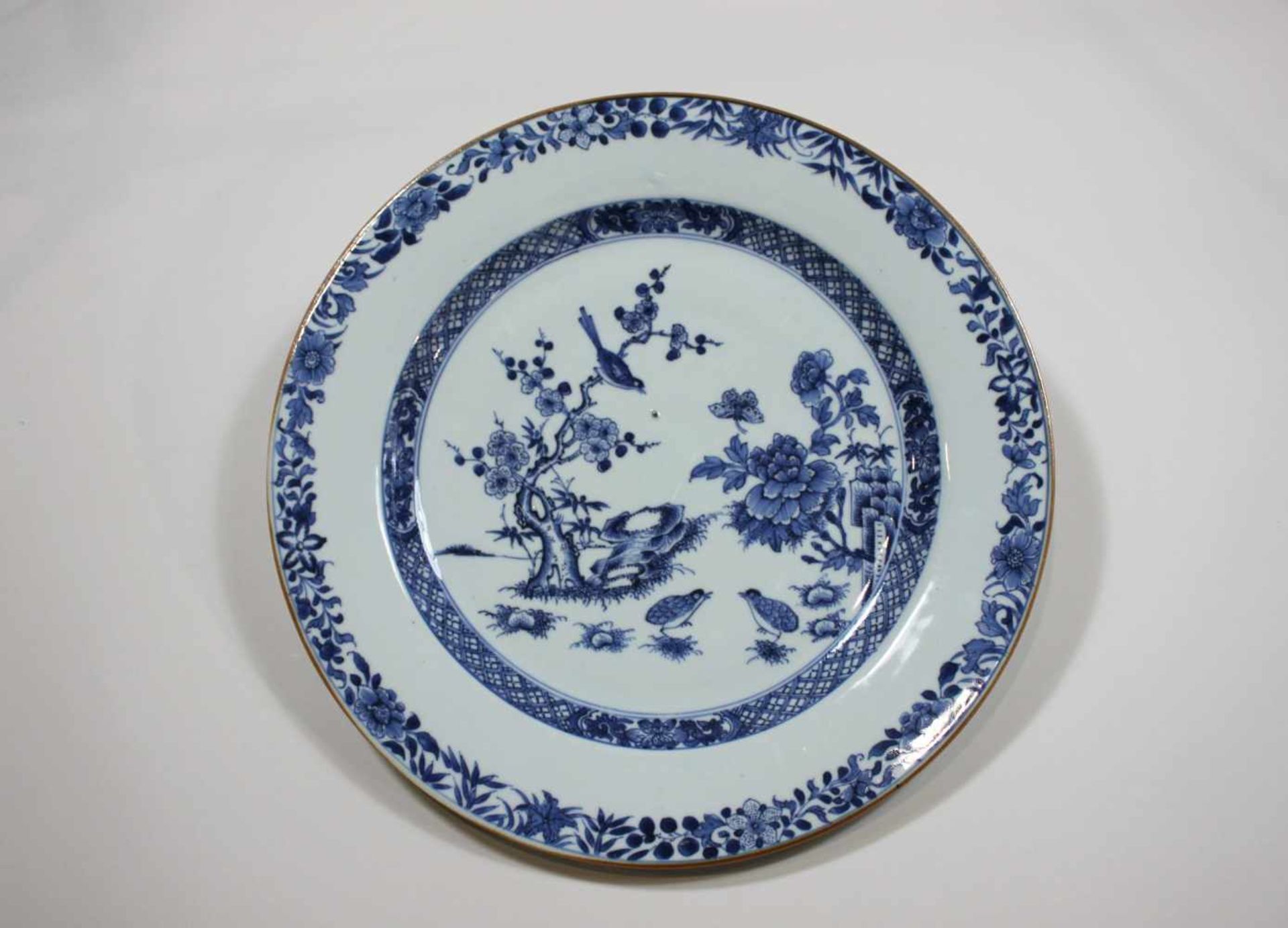 Großer Porzellanteller, China 18. Jh., blaues, florales Dekor unter Glasur. Dm.: 31,5 cm.