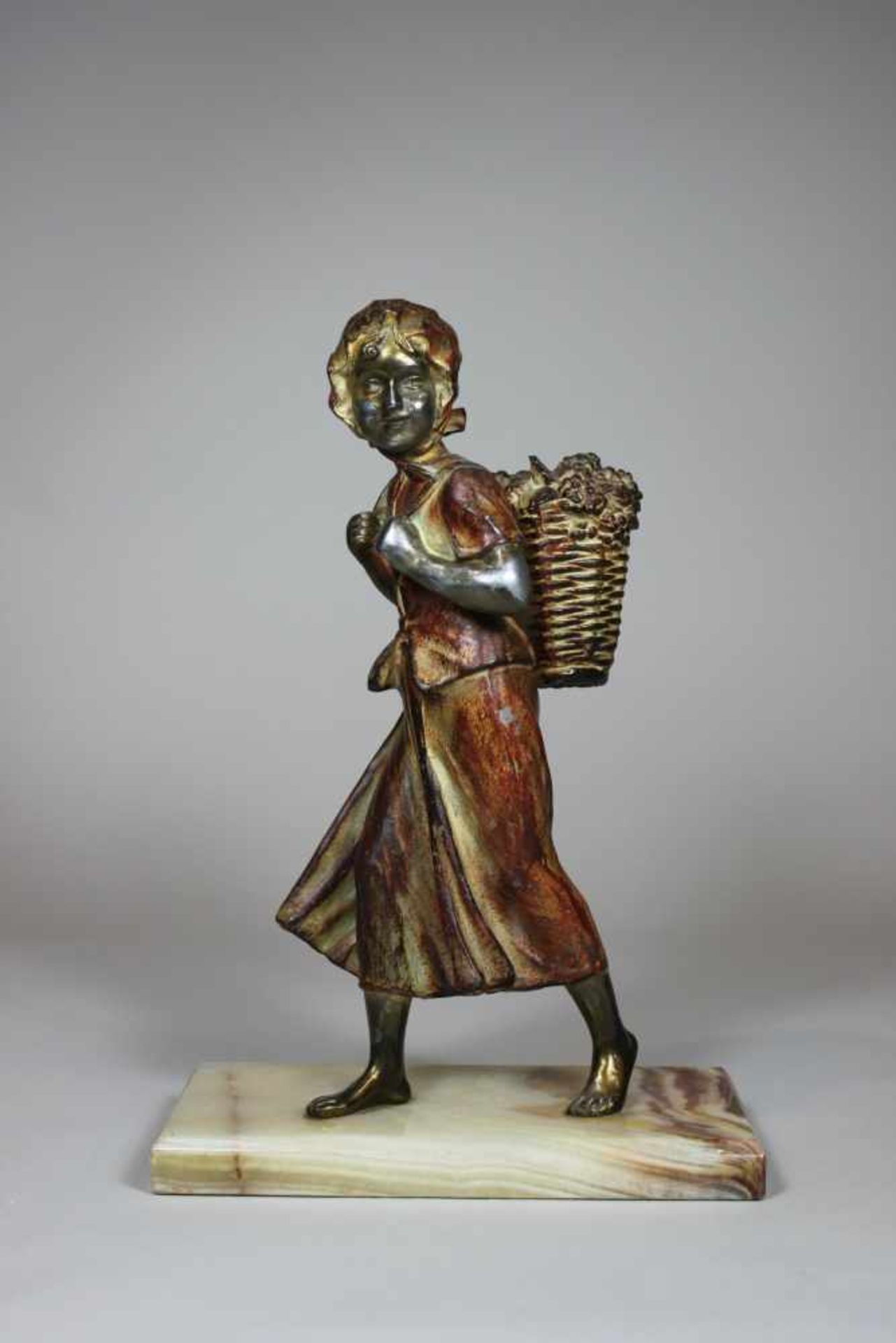 Mädchen mit Weinkorb, Metallfigur auf Marmorplinthe, H.: 31 cm.