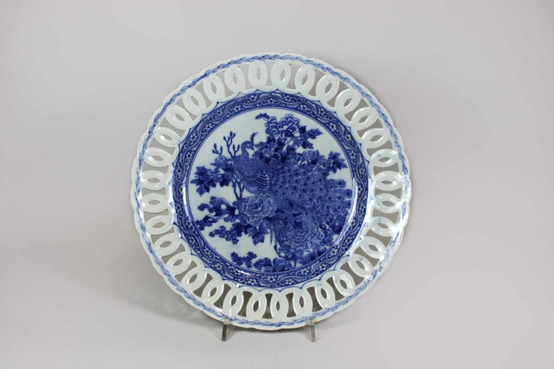 Durchbrochener Porzellanteller, China, blauer Dekor unter Glasur, im Spiegel ein Pfau in einer
