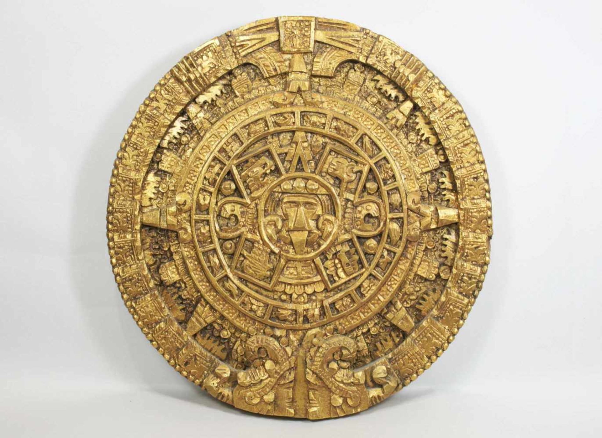 Goldene Reliefscheibe mit der Nachahmung des Maya Kalenders, Holz, geschnitzt. Maße: 36 x 35 x 3,5