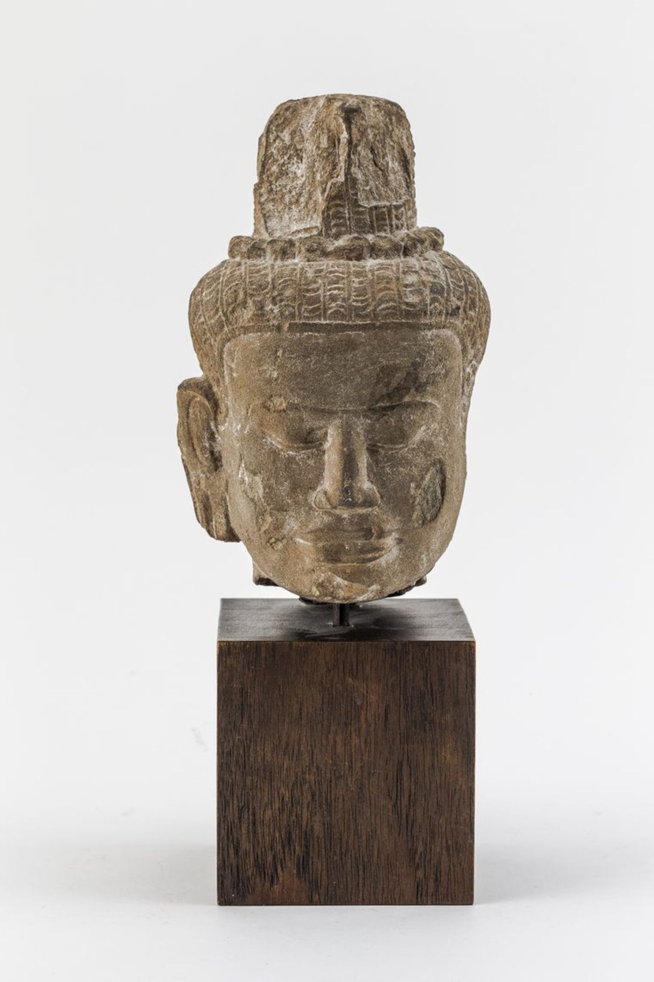 Kopf des Bodhisattva LokhesvaraSandstein. Auf würfelförmigem Holzsockel montiert. Vollplastisch