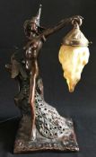 Jugendstil-Lampe, Bronzefigur, von Pfauen umgeben, mit einer orangenen Glaslampe in der Hand,