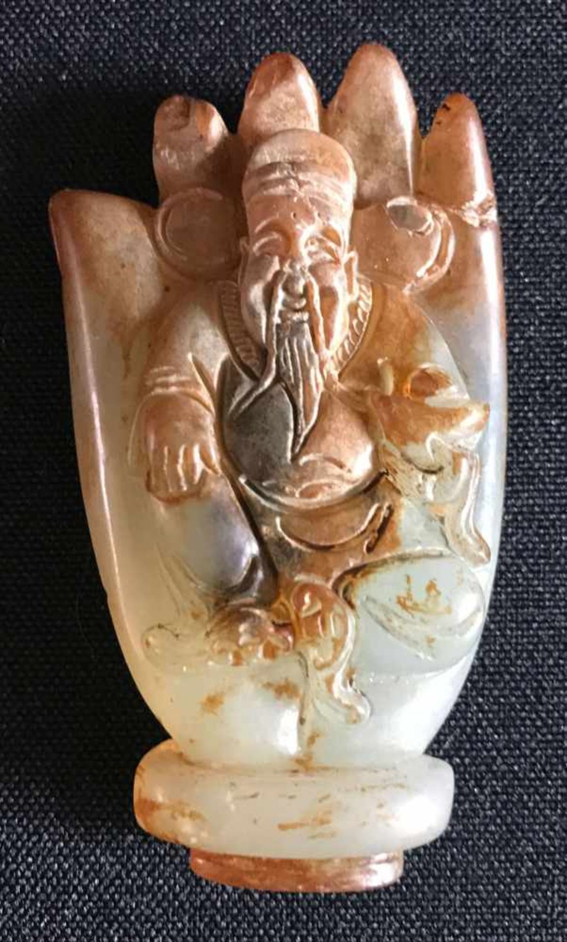 Jadehand, grün-braune Färbung des Steines, mit geschnitztem Buddha in der Handfläche,