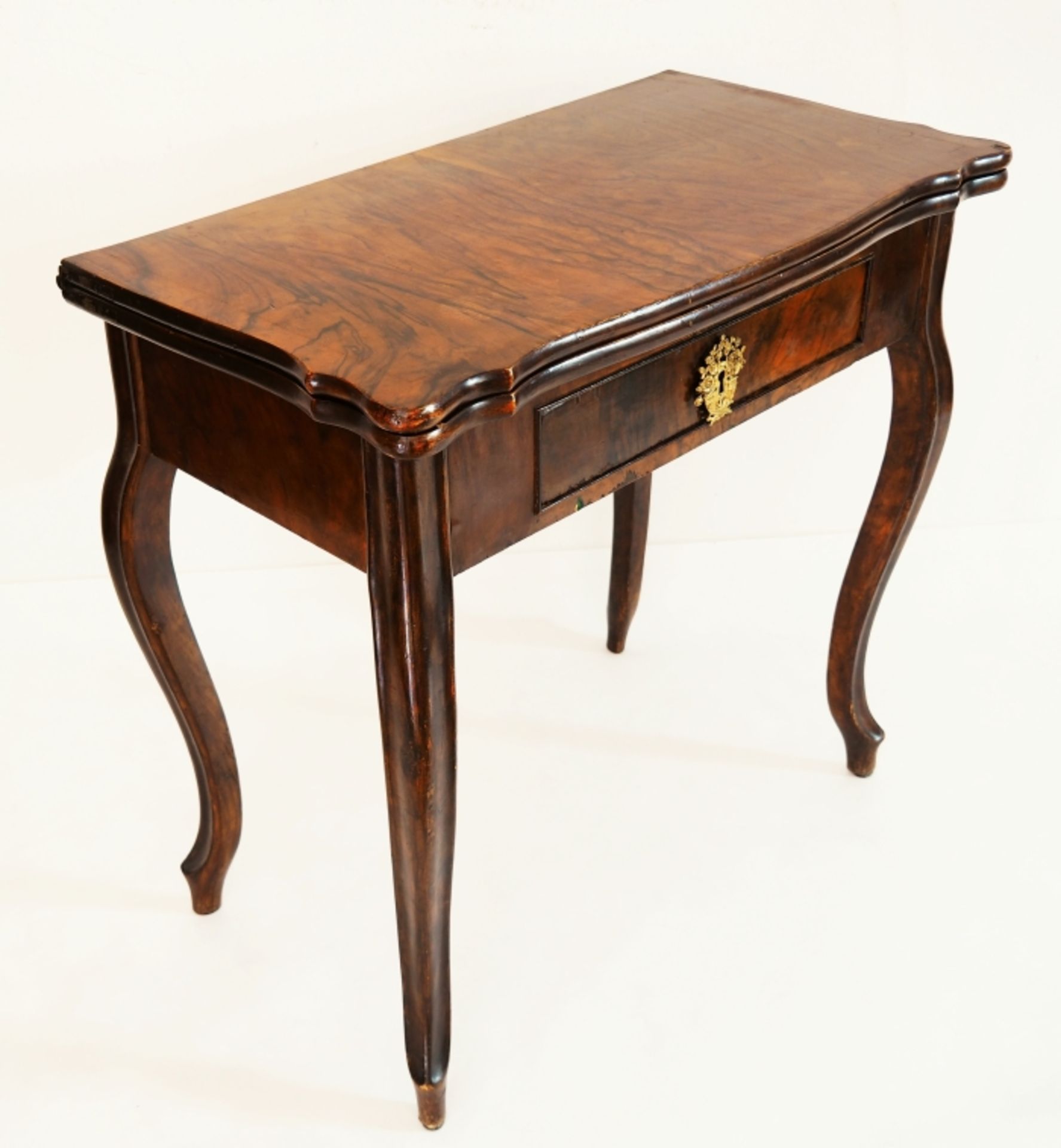 Spieltisch, um 1850, Nußbaum mit schöner Maserung. Auf vier geschwungenen hohen Beinen, dreh- und
