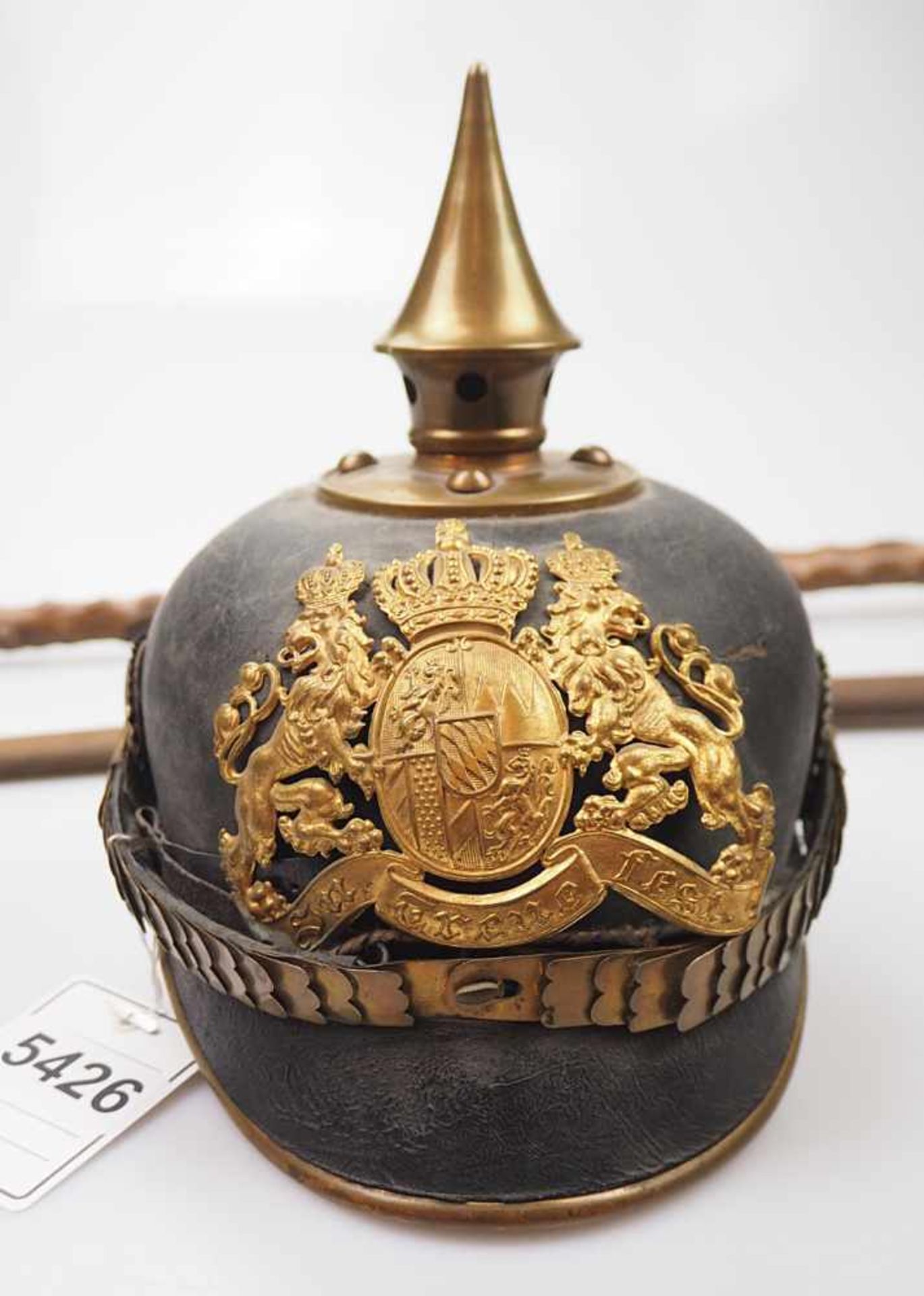 1 Konv. Militaria: 1 Helm mit Spitze wohl um 1880/1900Lederglocke mit Messingappliken,, seitlich