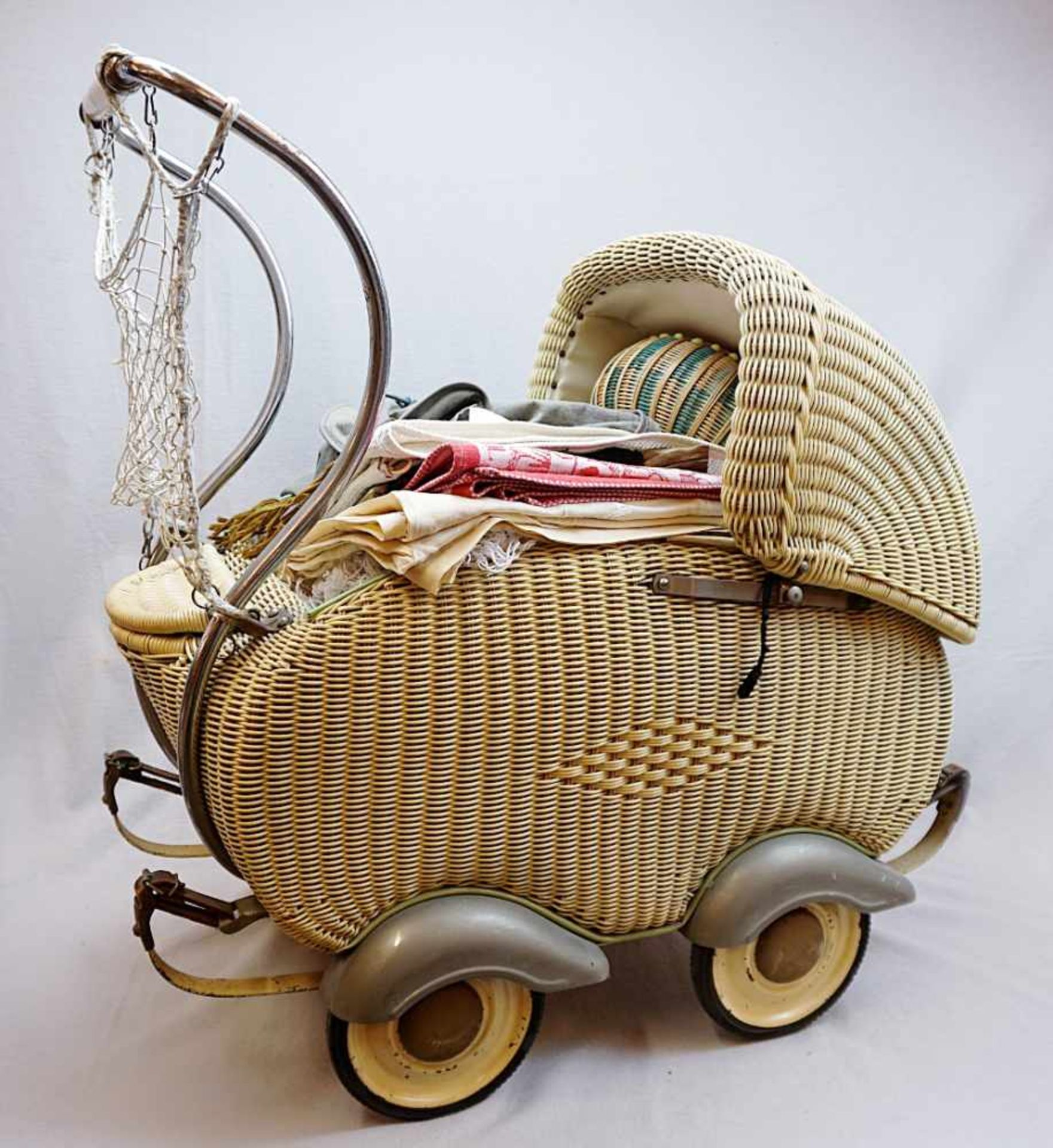 1 Puppenwagen wohl 1950er/60er JahreKorbgeflecht auf Eisengestell mit versch. Textilien H ca. 69cm
