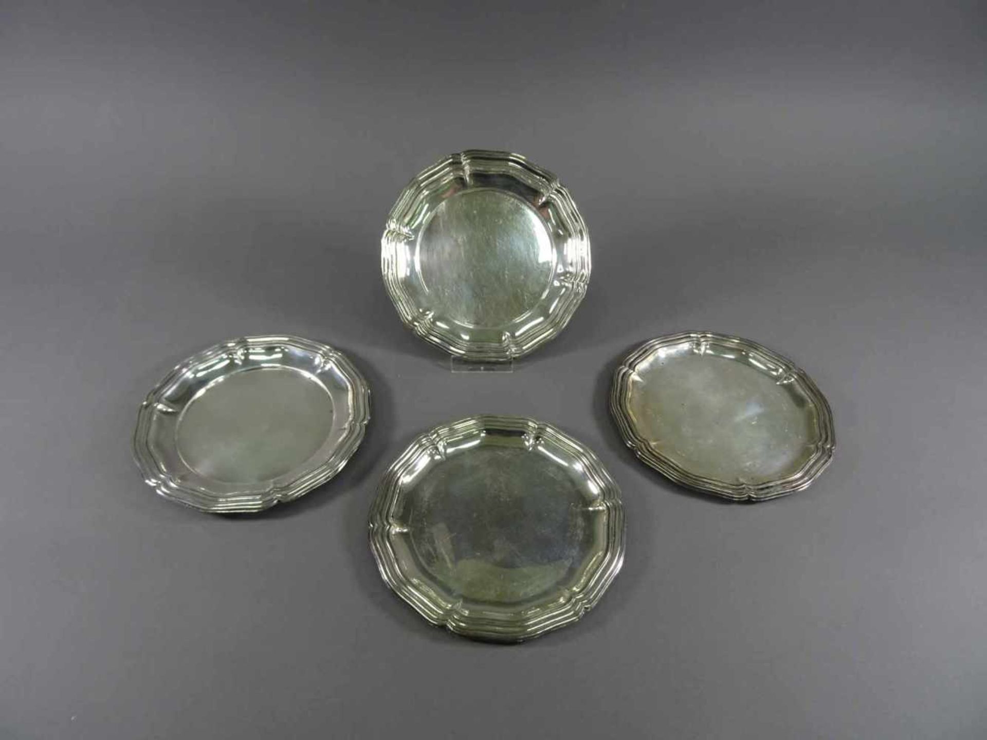 Vier verschiedene Flaschenuntersetzer800 Silber, Barockstil, D = 14,5 cm, ca. 281 g, Kratzspuren
