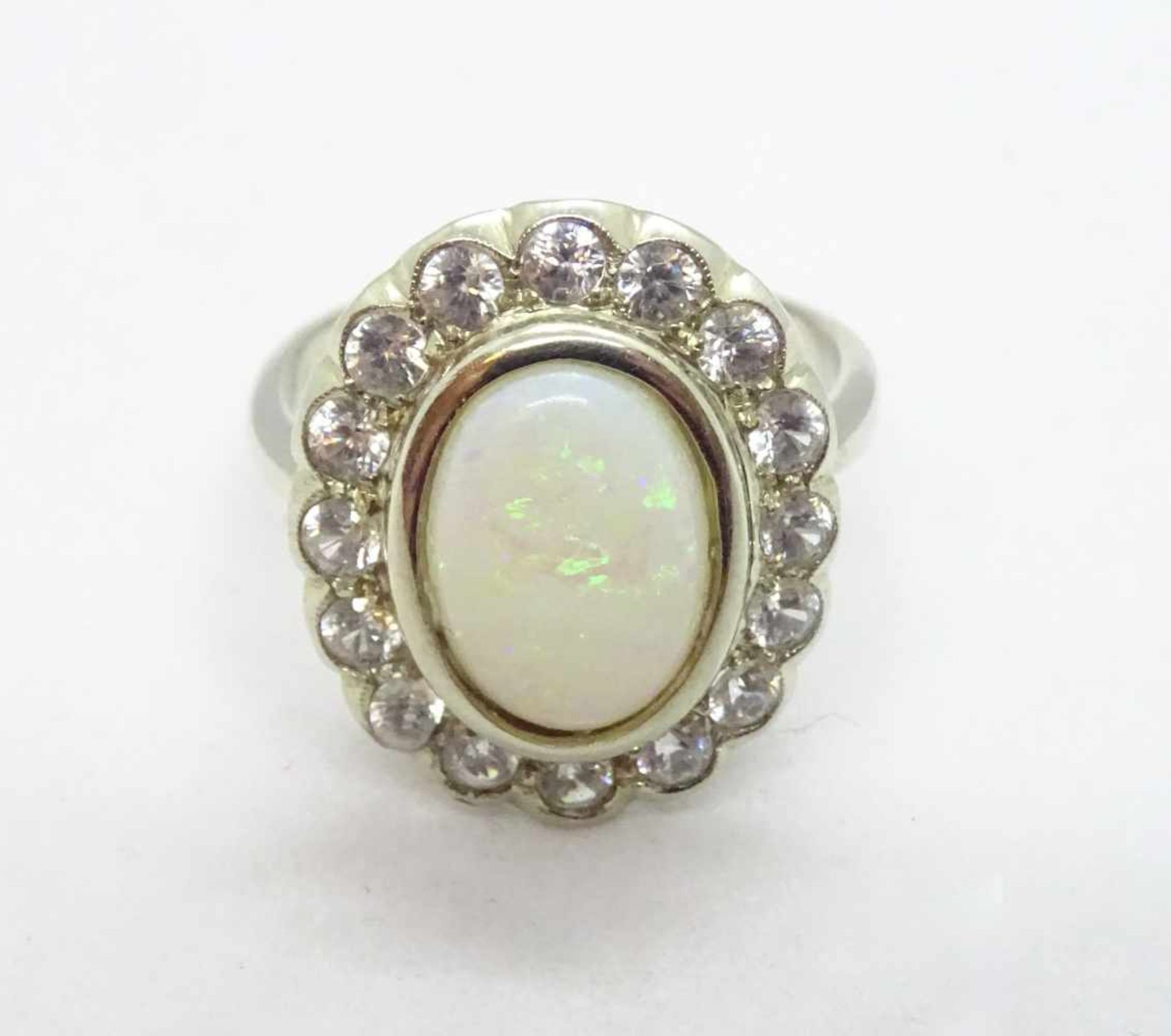 Ring, 14 K WGbesetzt mit einem Opal, umgeben von 16 farblosen Dekorsteinen, RW 54, ca.