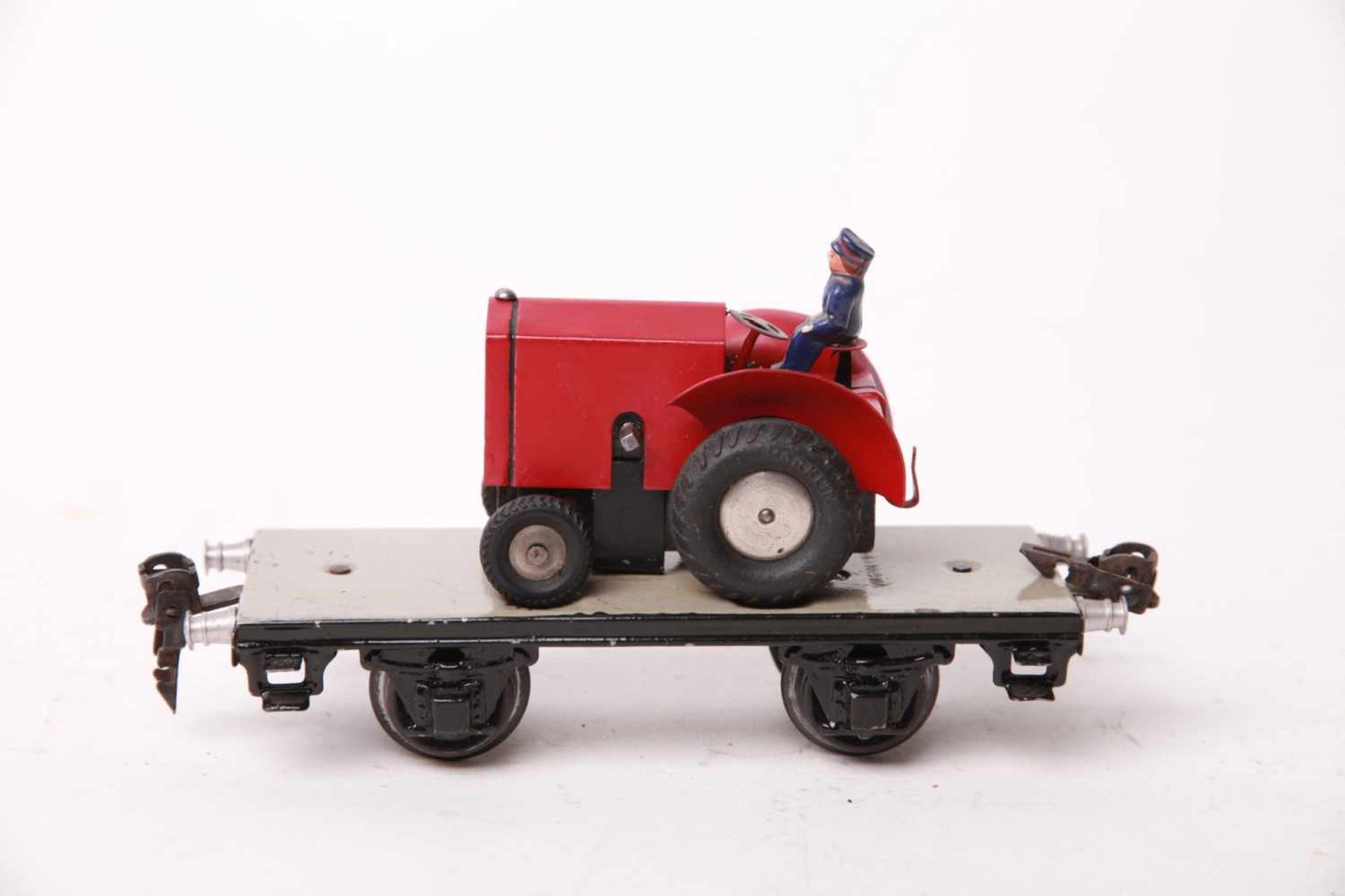 Märklin S 0, 1766 Plattformwagen mit rotem Traktor. Uhrwerk funktionierend. L16,5cm, Z1-2