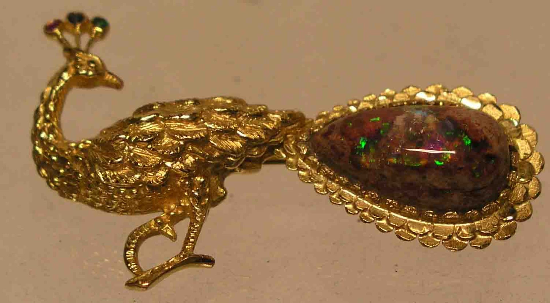 Brosche in Pfau-Form. 14 kt. Gelbgold, mit einem Bolunder-Opal, 1 Rubin, 1 Saphir und 1