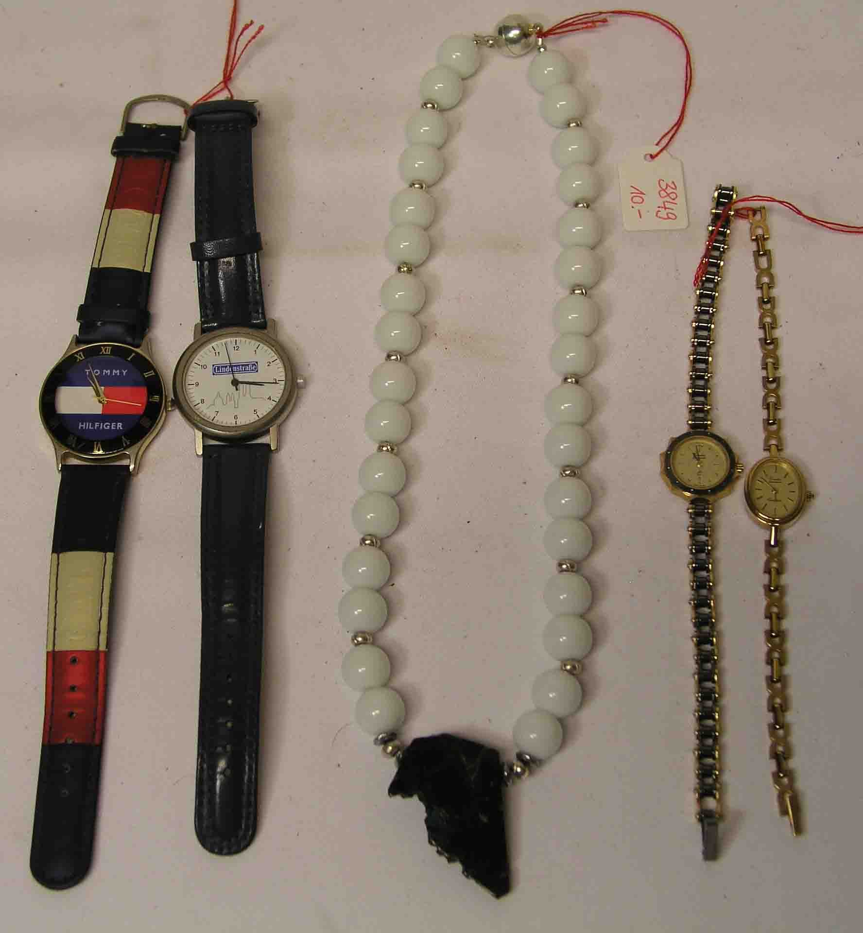 Halskette und vier Armbanduhren. Kette aus weißen Kugeln, mittiger grüner Schmuckstein.