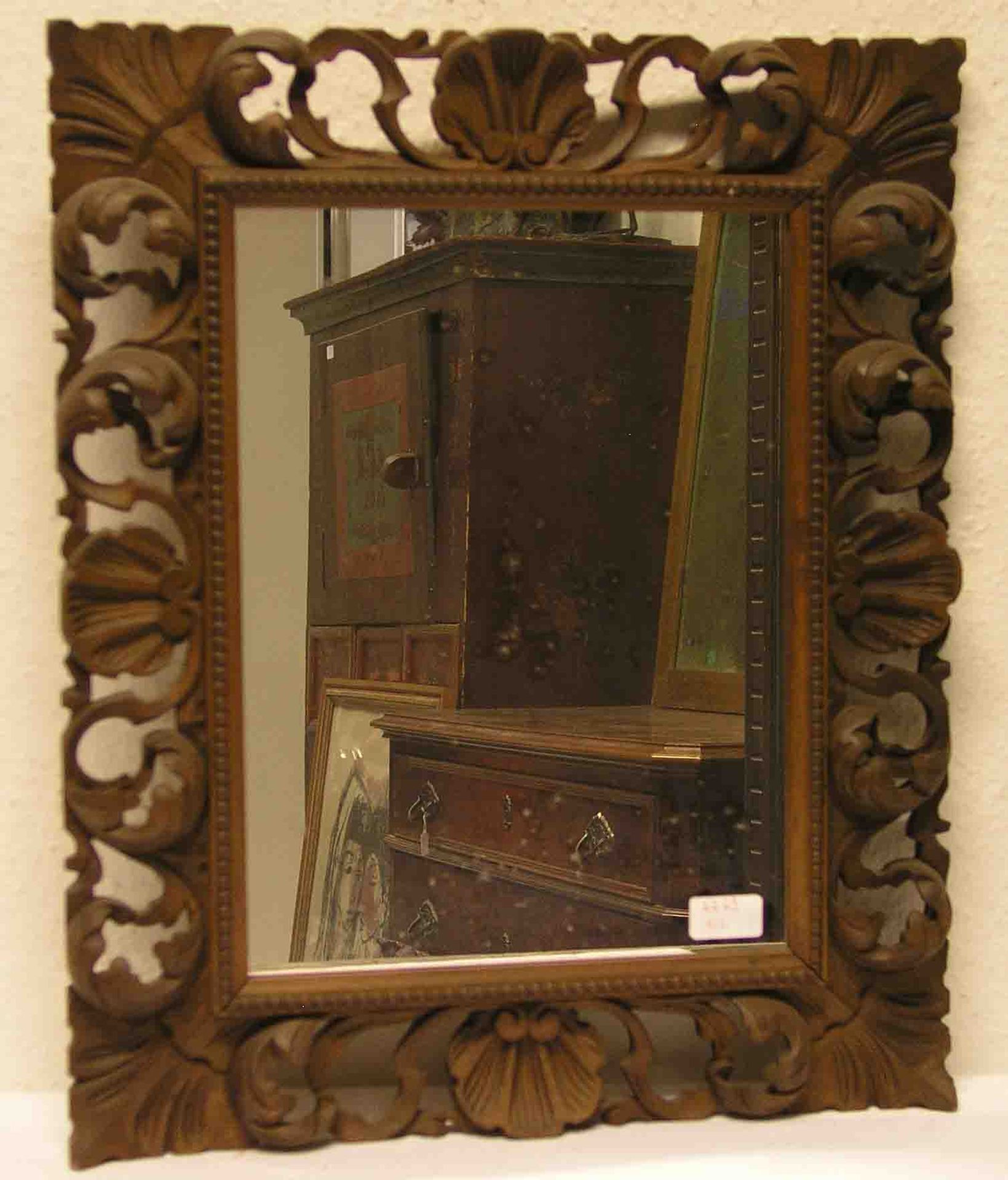 Spiegel im geschnitzten Holzrahmen. Gesamtmaße: 56 x 47cm.