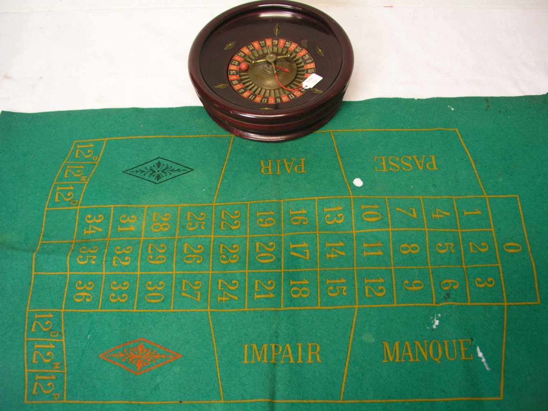 Tisch-Roulette. Filzteppich (beschädigt), Schale aus Holz, Durchmesser 22cm. Mit zwei